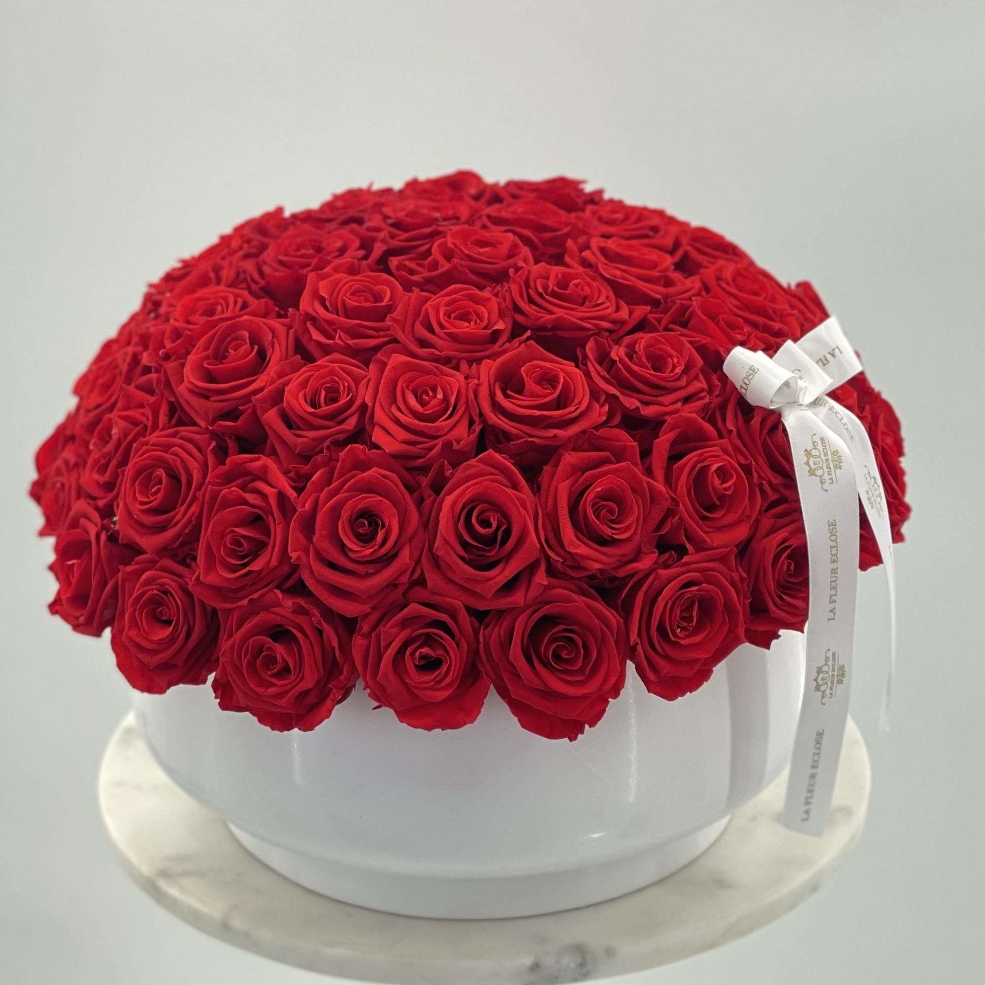 Preserved red roses in a white vase