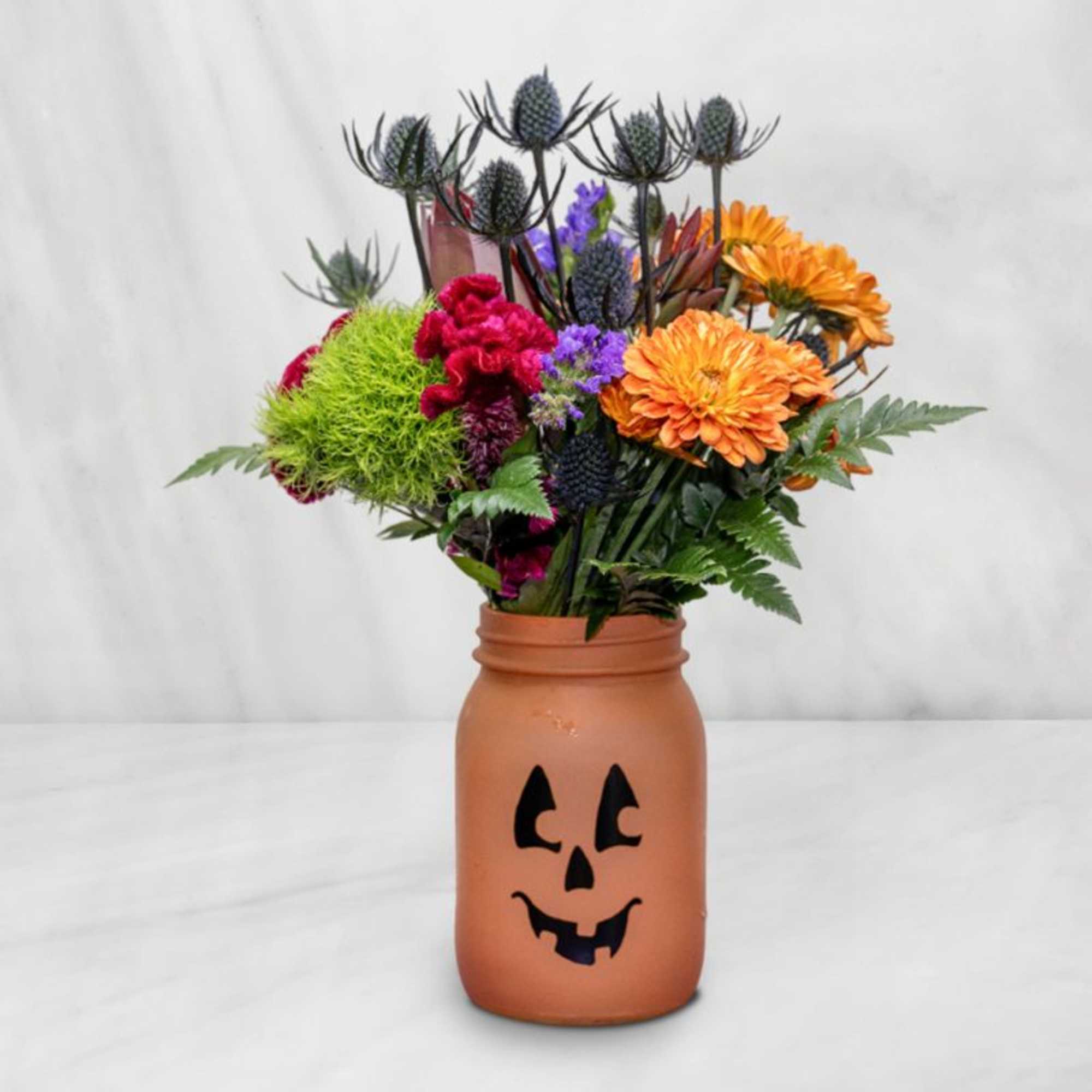 Halloween bouquet in a jack-o'-lantern jar vase