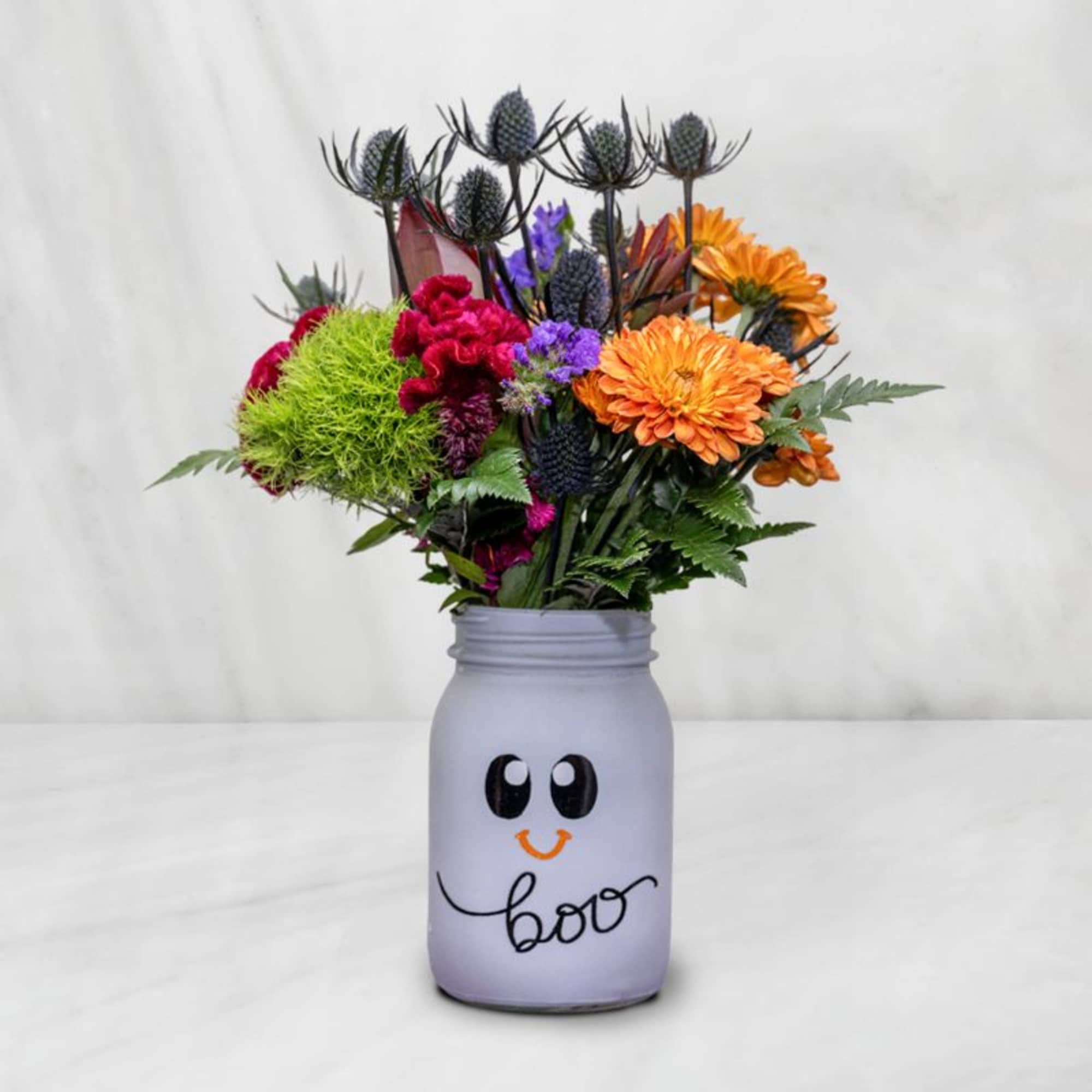 Colorful bouquet in a painted mason jar with a smiling face