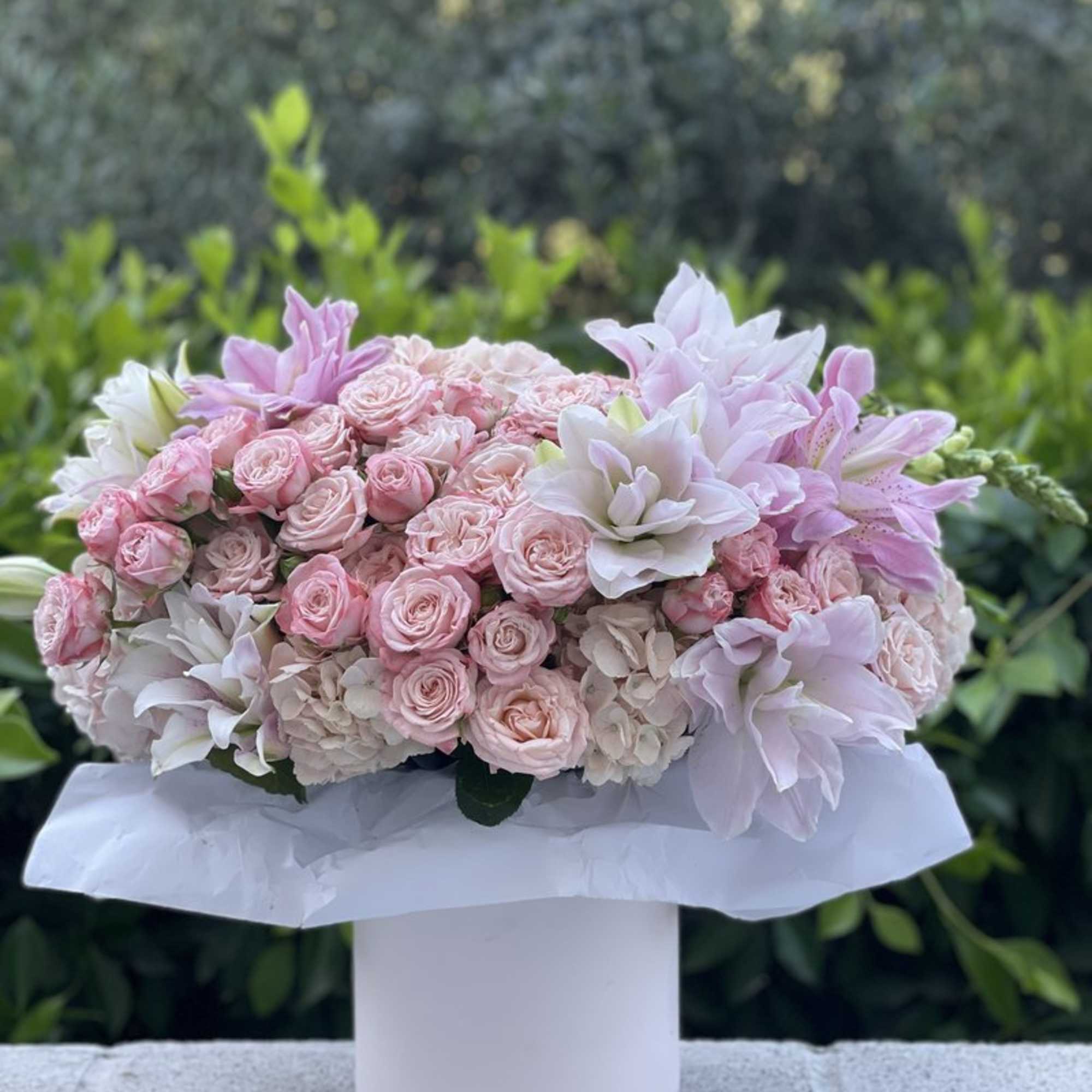 Pink and white bouquet of roses and lilies in a white box