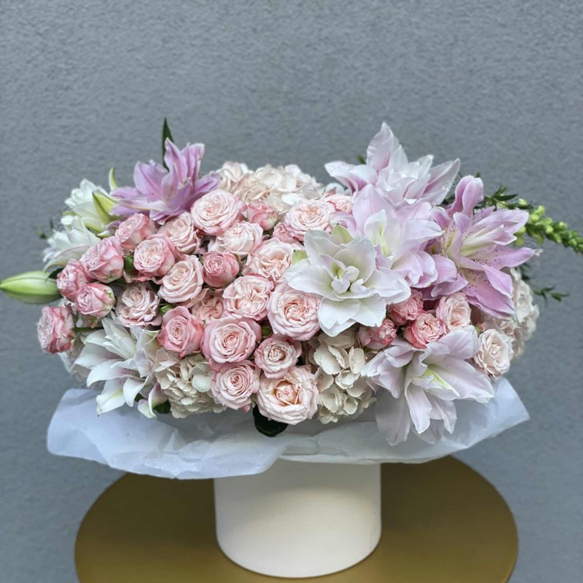 Pink and white floral arrangement in a white hat box