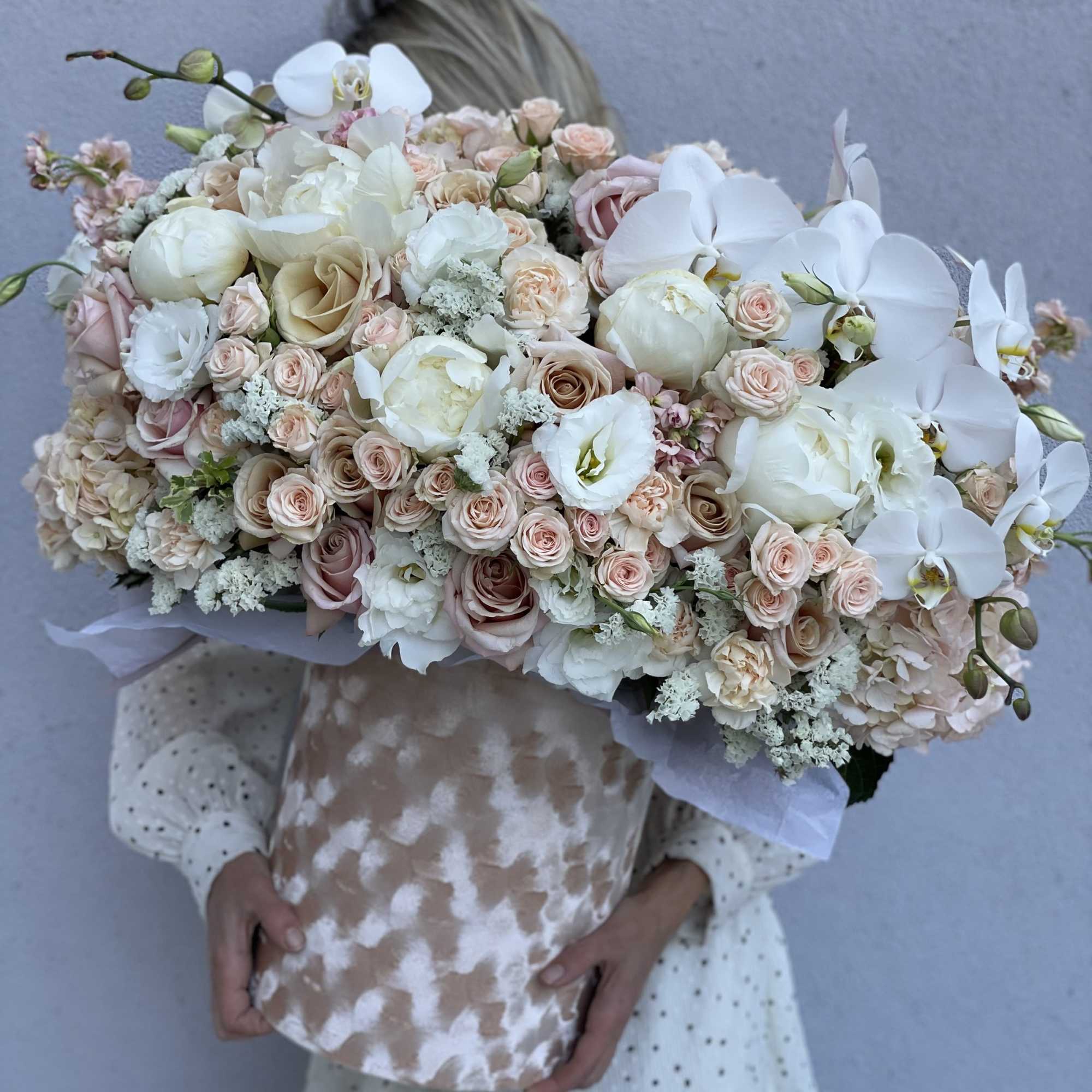 Large bouquet of white orchids, blush roses, and pale peonies