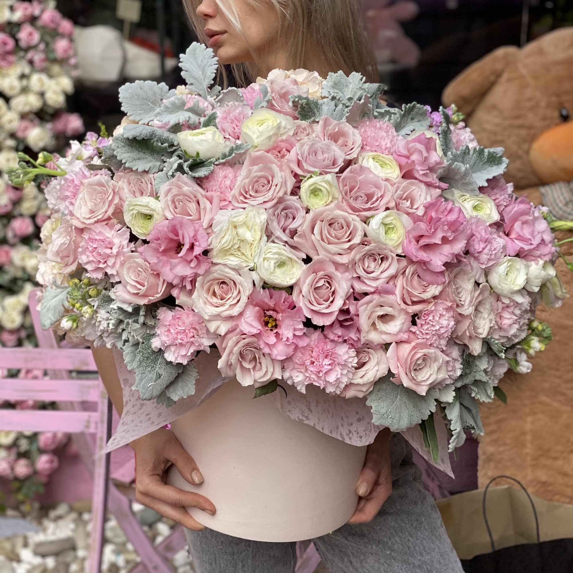 Large pink bouquet in a pale round box held by a person