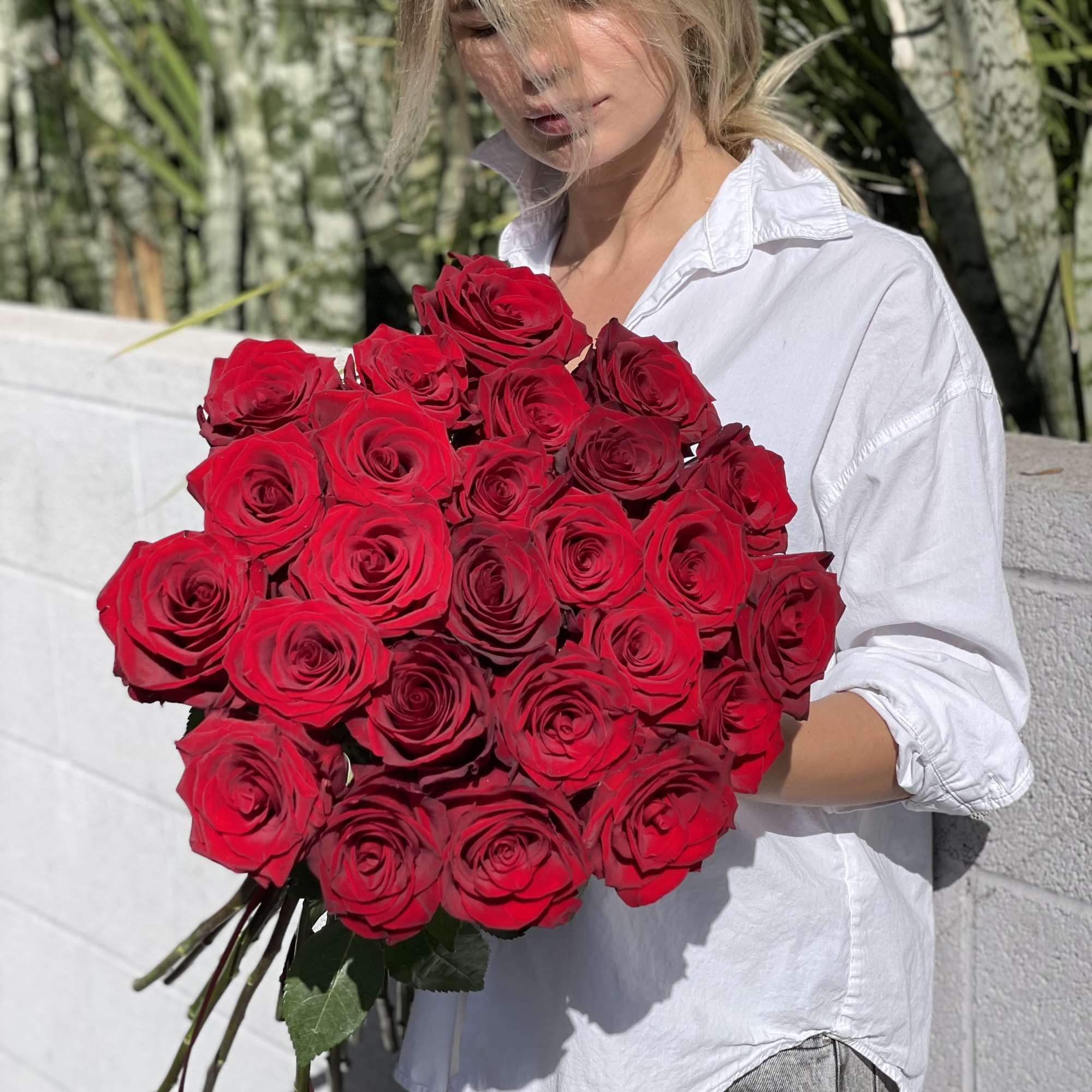 Woman holding a large bouquet of red roses, photo 5 of 15