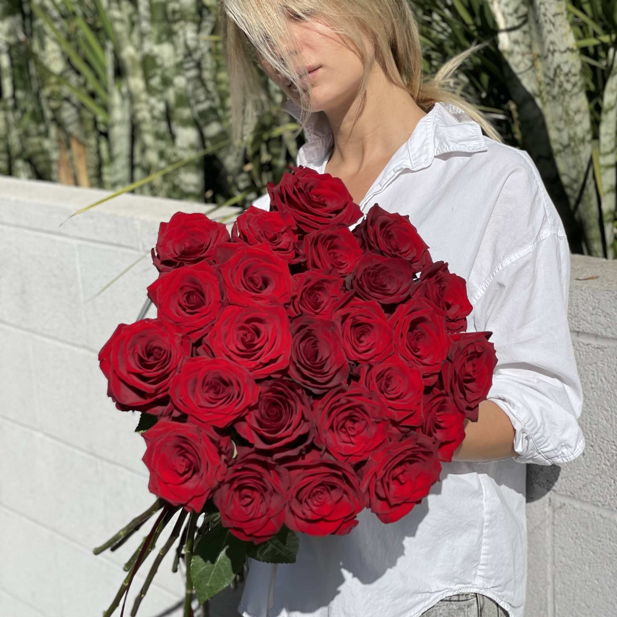Woman holding a large bouquet of red roses, photo 7 of 15