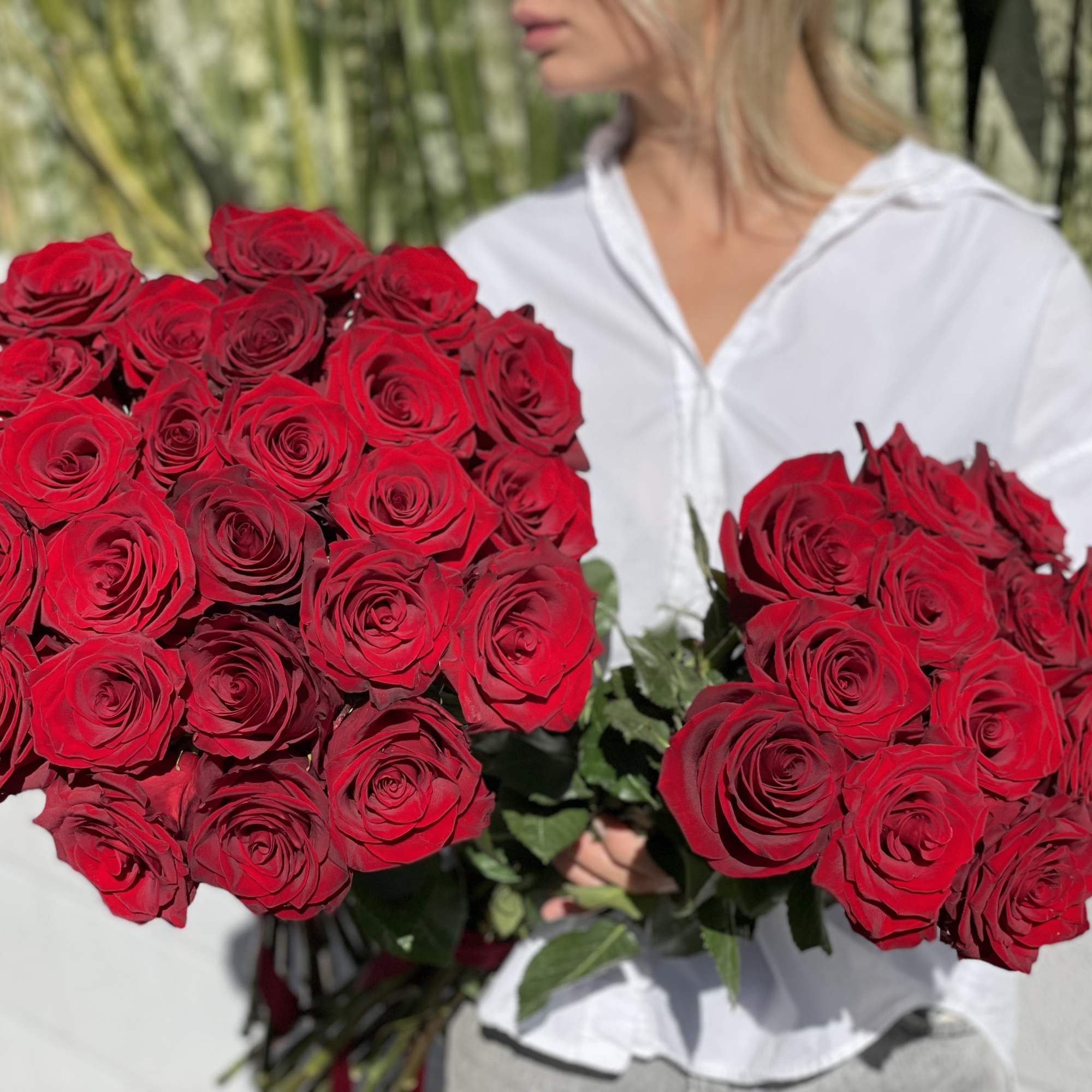 Woman holding two large bouquets of red roses, photo 12 of 15