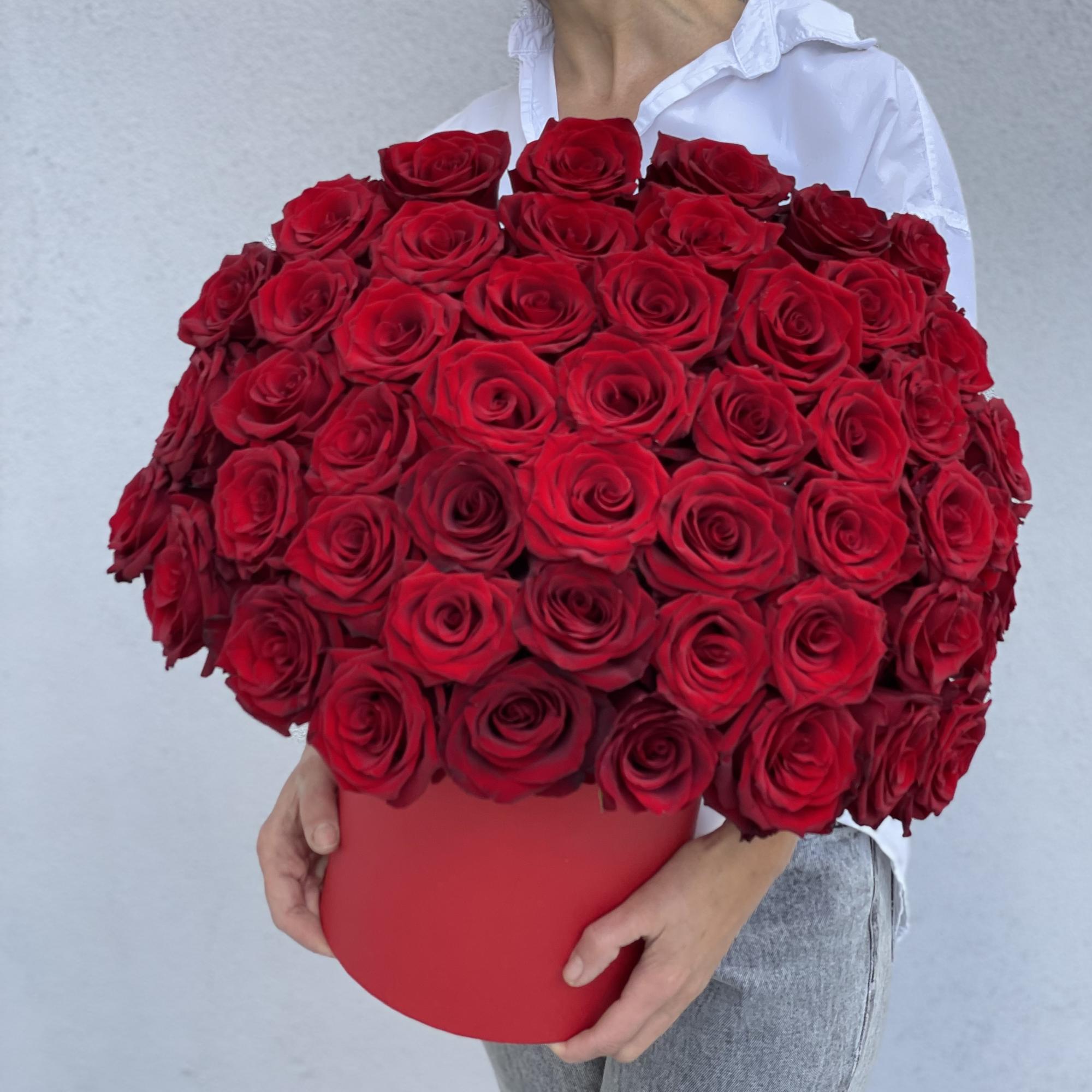 Large bouquet of red roses in a red box held by a woman