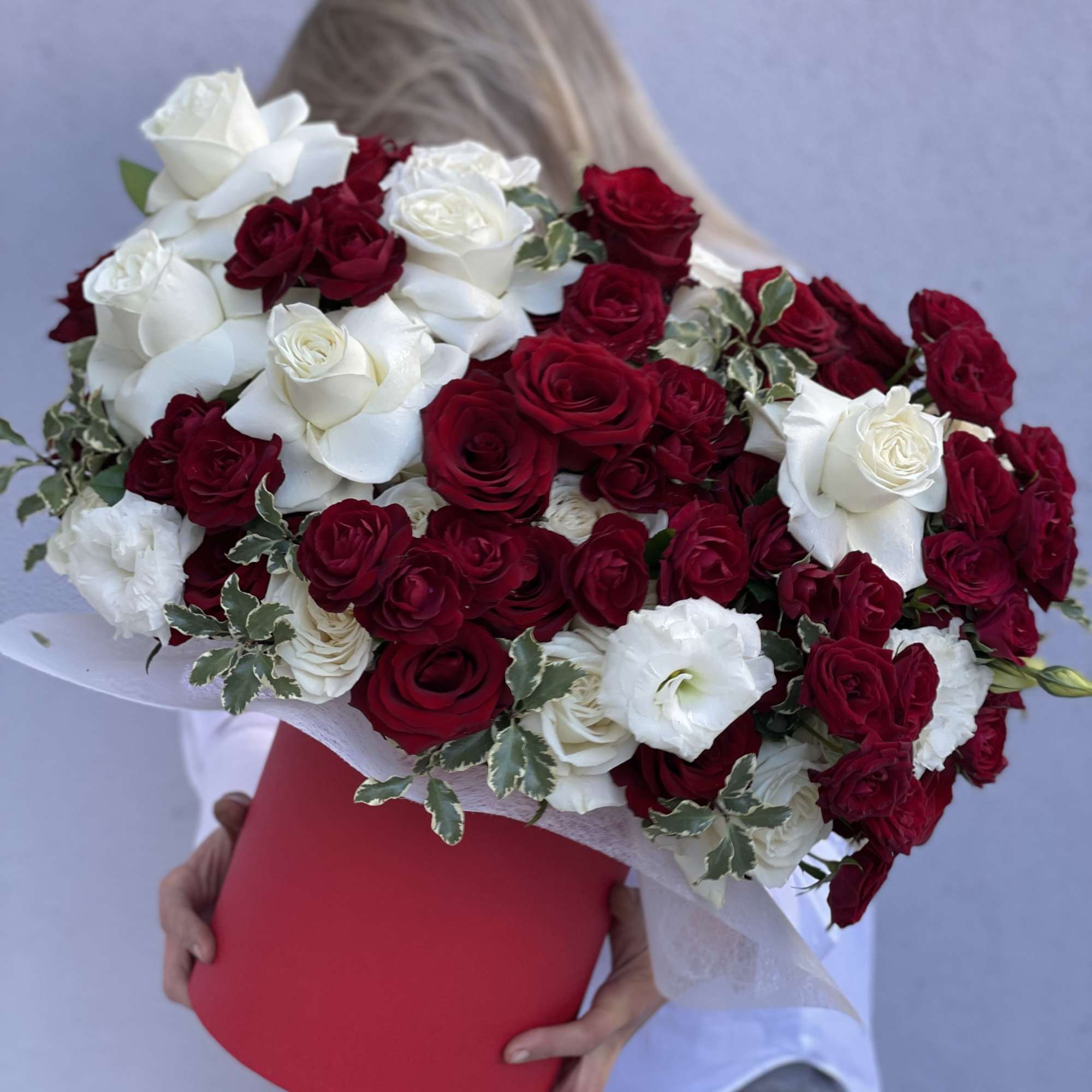 Large bouquet of red and white roses in a red box