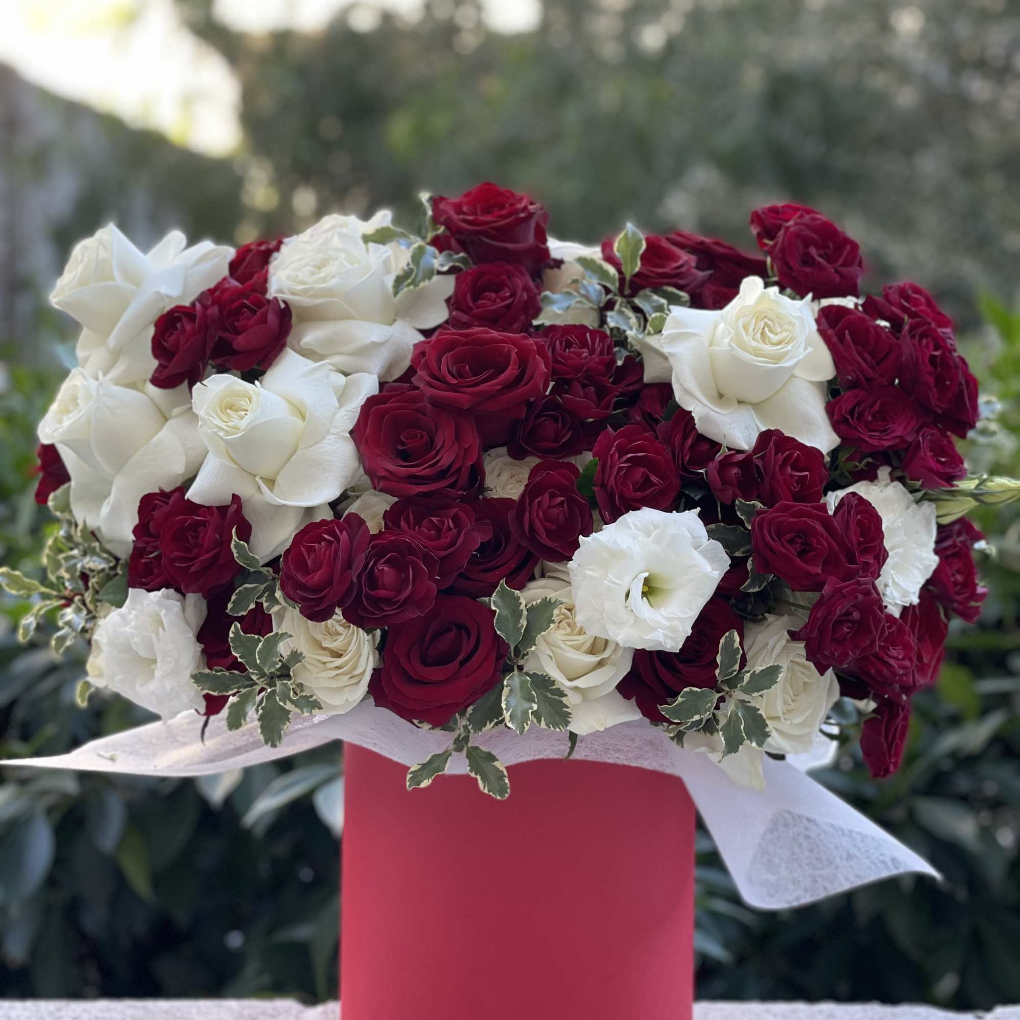 Red and white rose bouquet in a pink box
