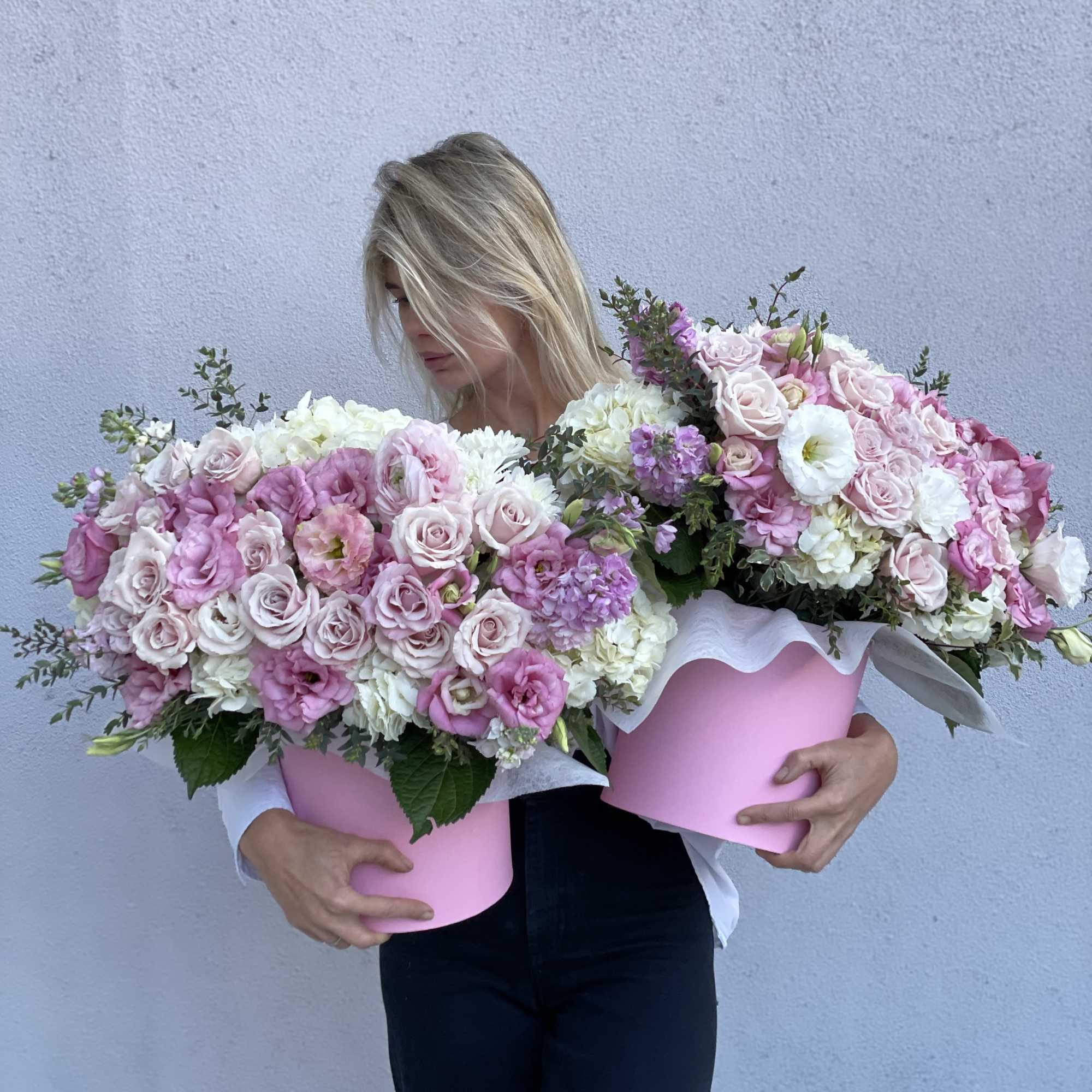 Woman holding two large pink and white flower boxes, photo 4 of 7