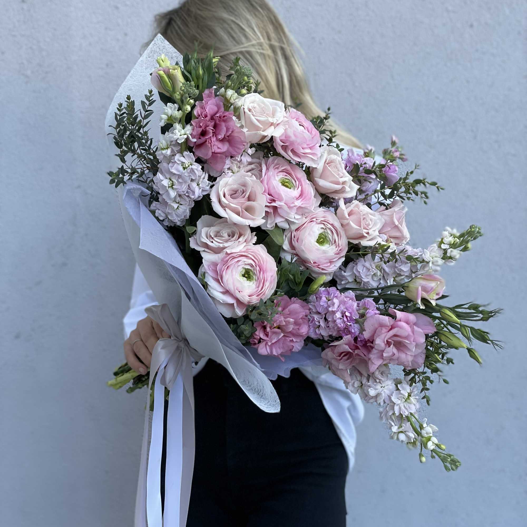 Large pink and white bouquet wrapped in pale paper