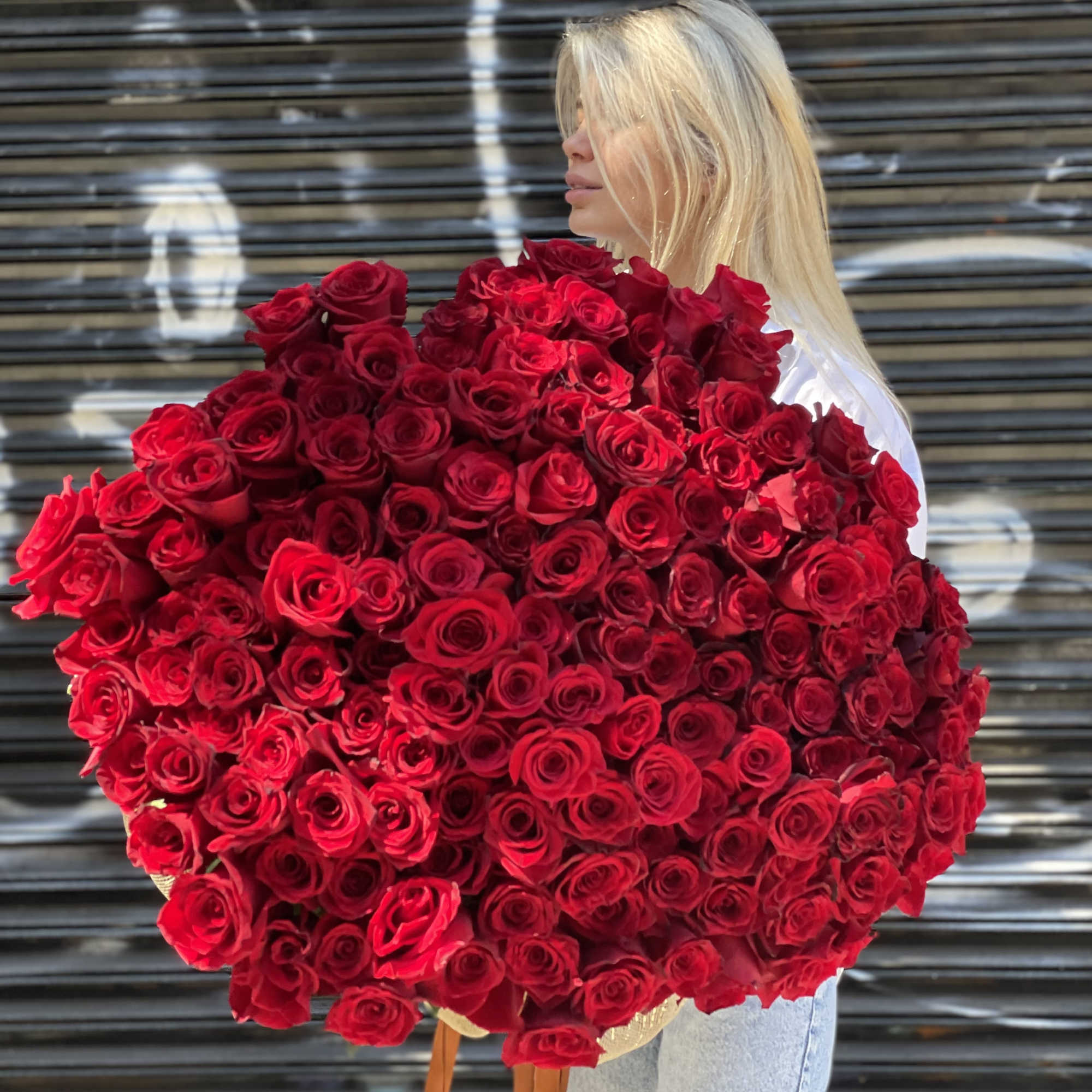 Woman holding a large bouquet of red roses, photo 5 of 6