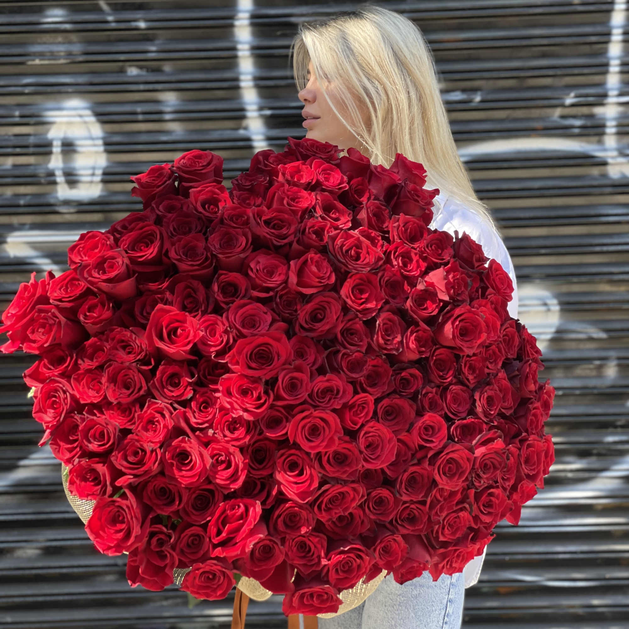 Woman holding a large bouquet of red roses, photo 6 of 6