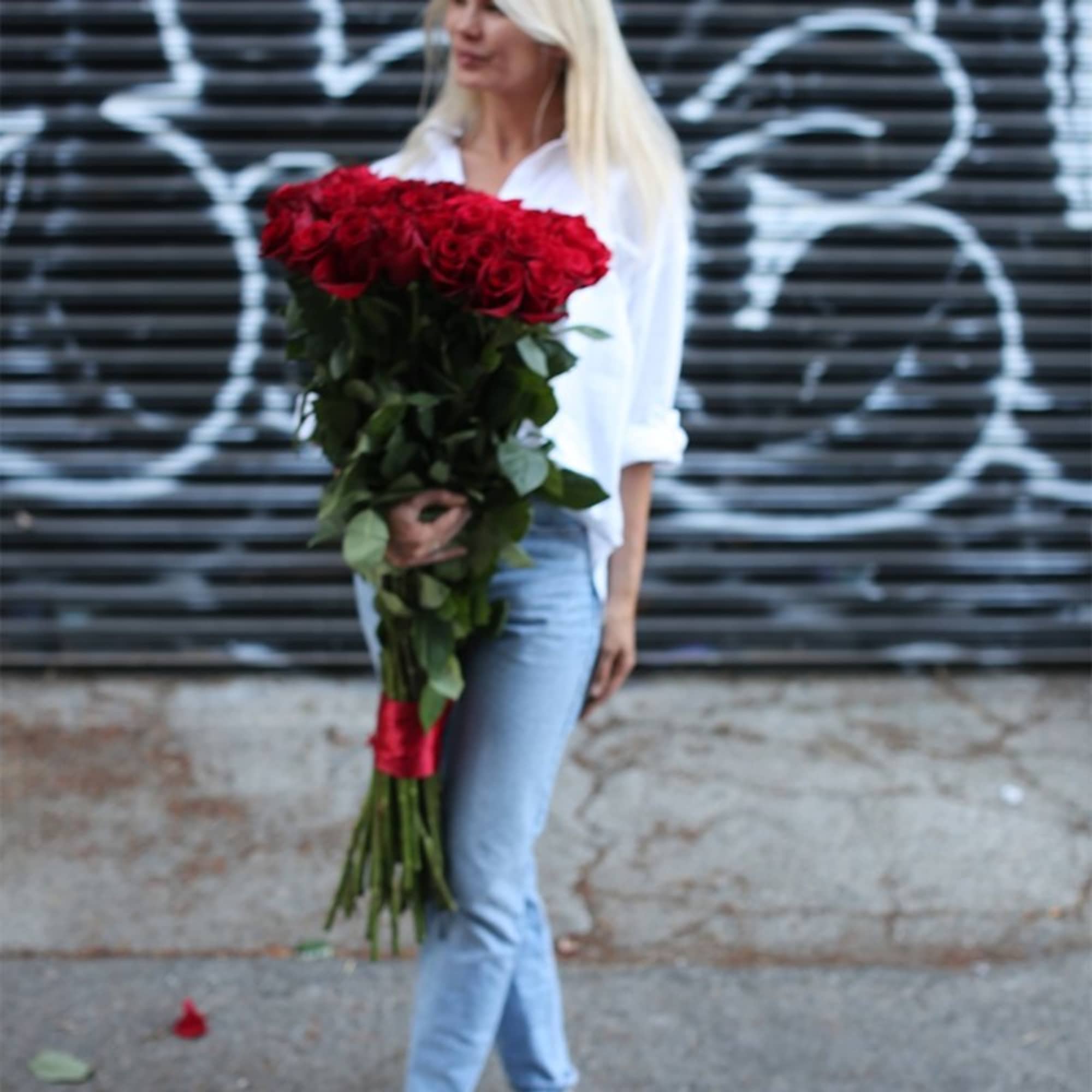 Woman holding a large bouquet of red roses, photo 2 of 3