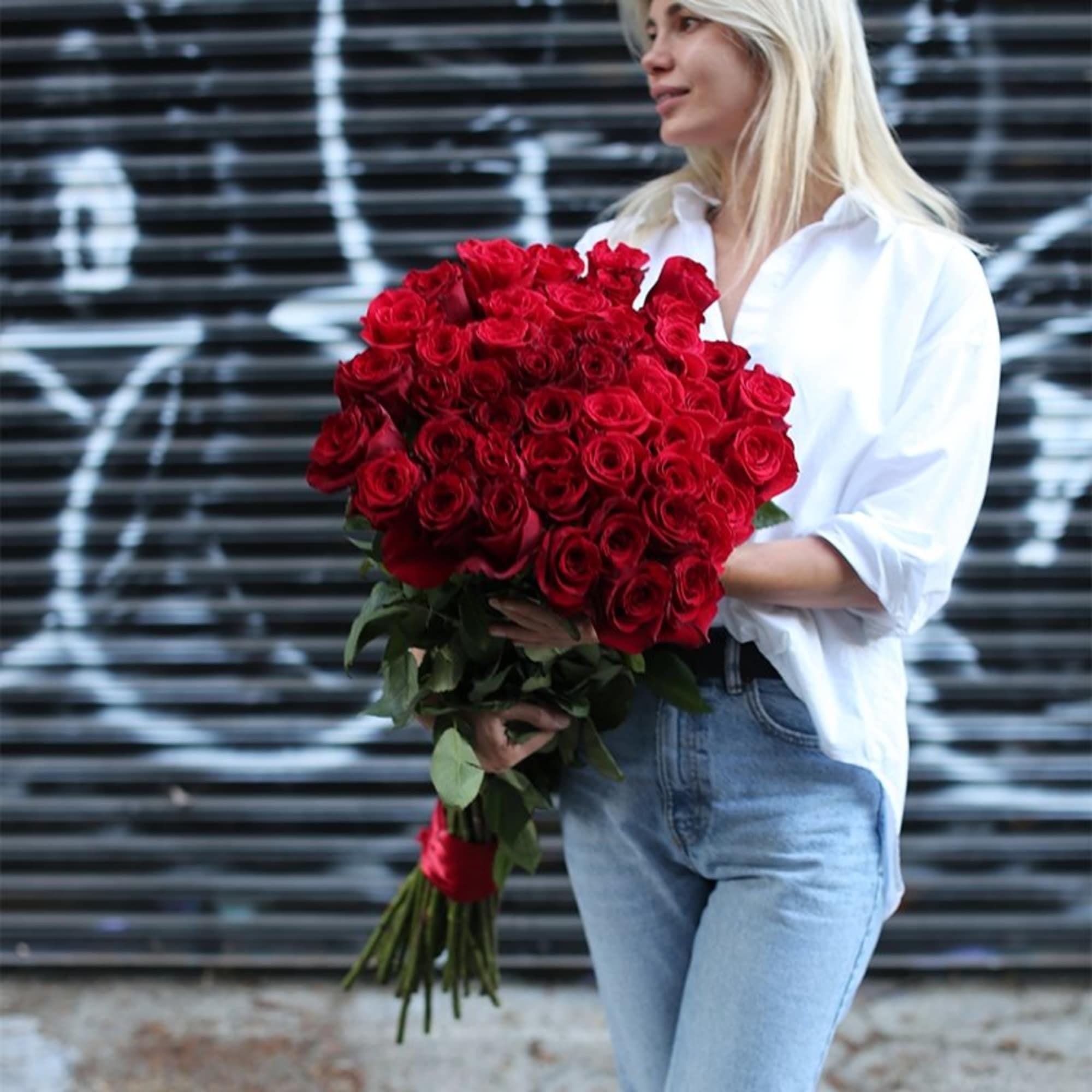 Woman holding a large bouquet of red roses, photo 3 of 3