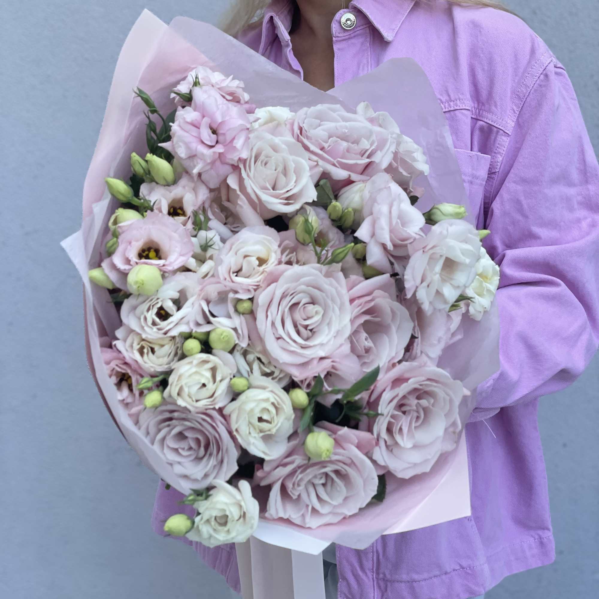 Hand-tied bouquet of pale pink and white roses with pink wrapping