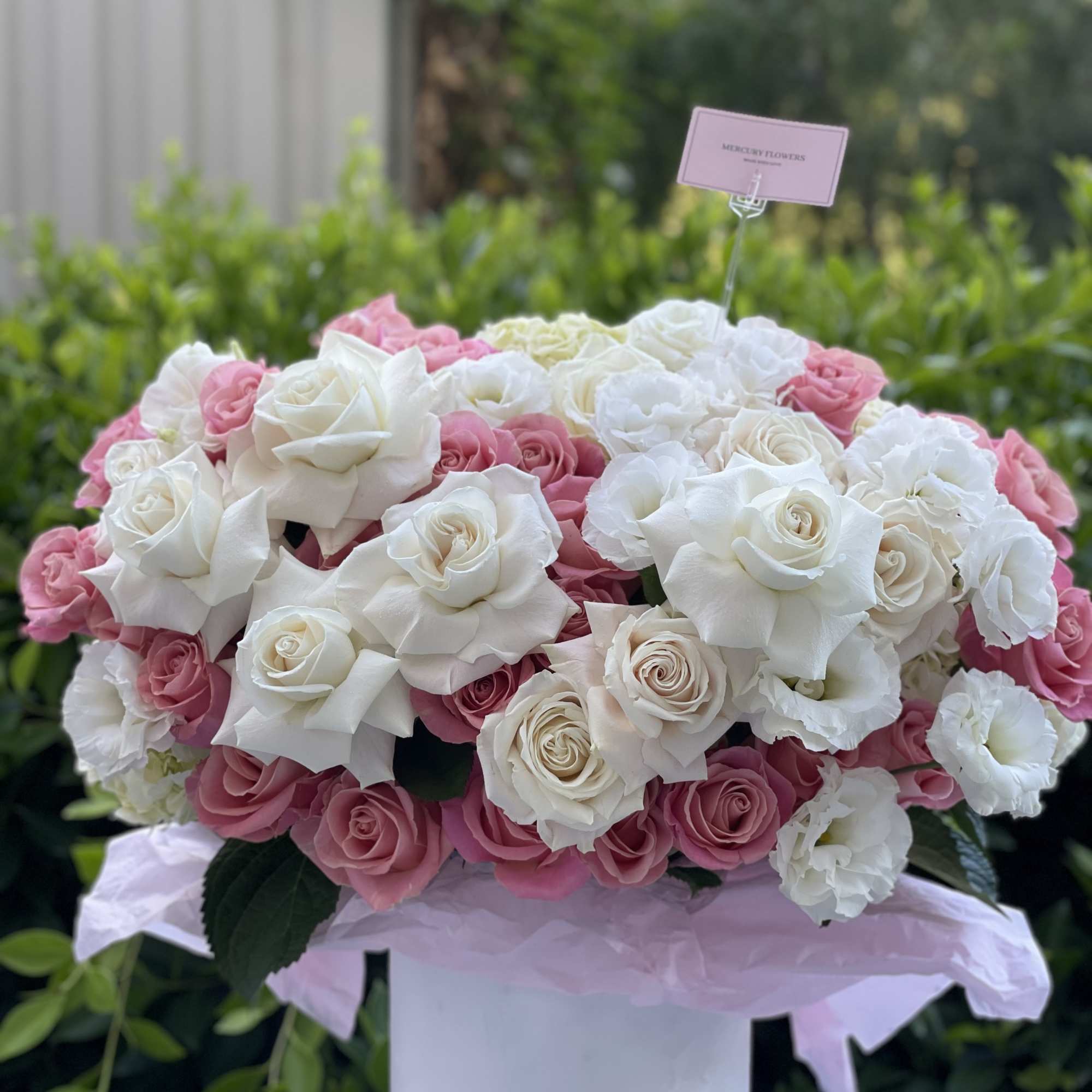 Pink and white rose arrangement in a white hat box