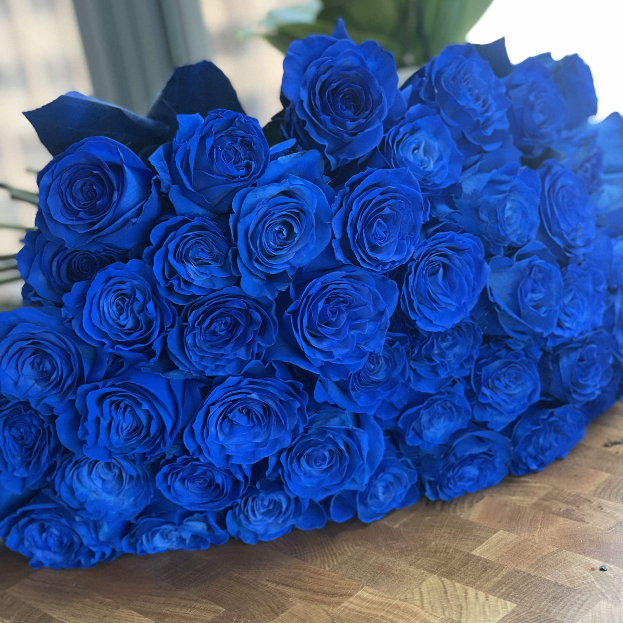 Large bouquet of vivid blue roses on a table