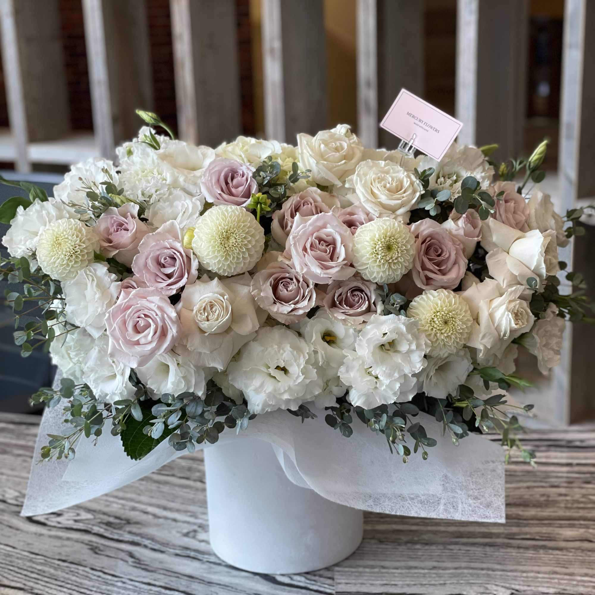 Pastel rose and white flower arrangement in a white box