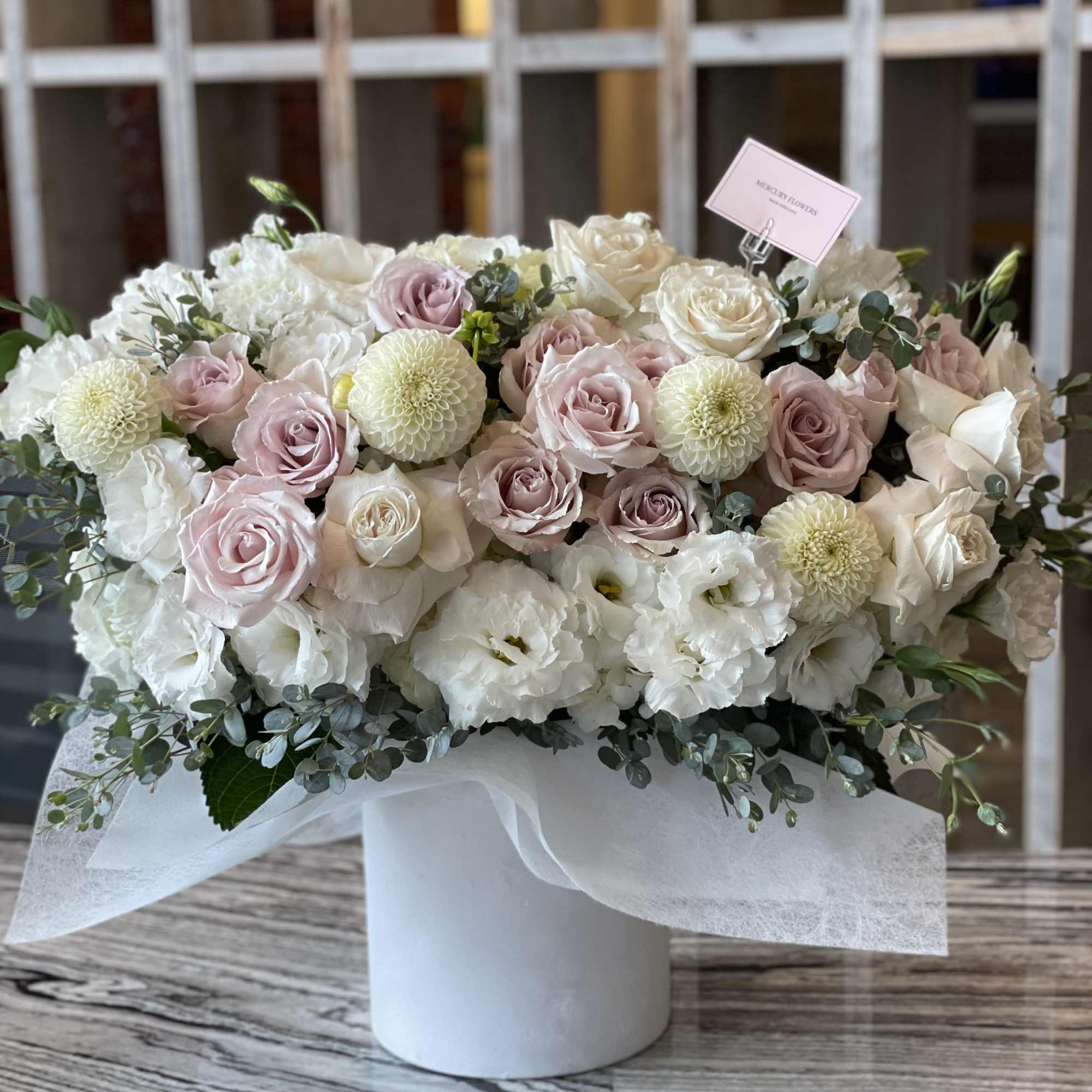 Pastel rose and white floral arrangement in a white box