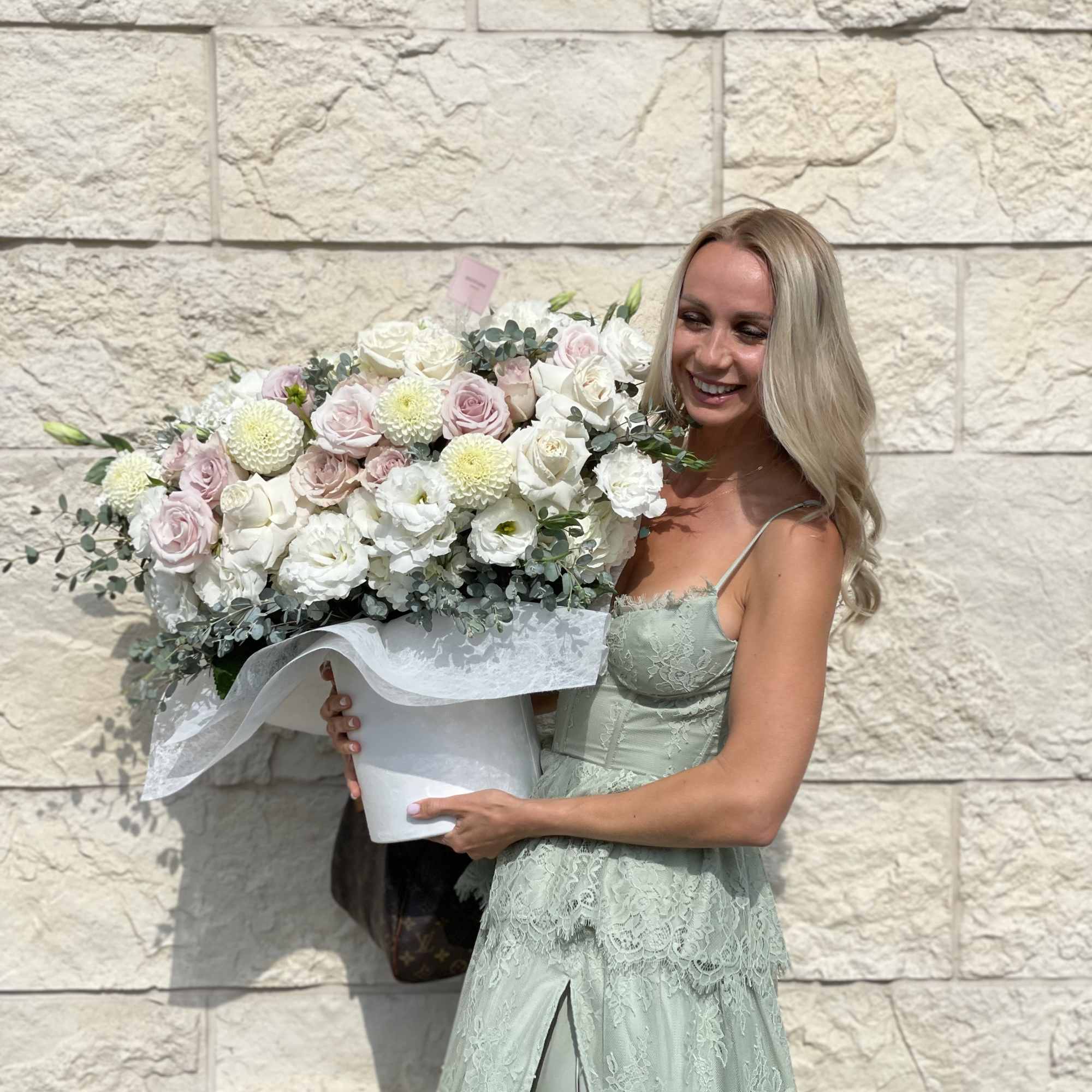 Woman holding a large bouquet of pale pink and white flowers, photo 9 of 9