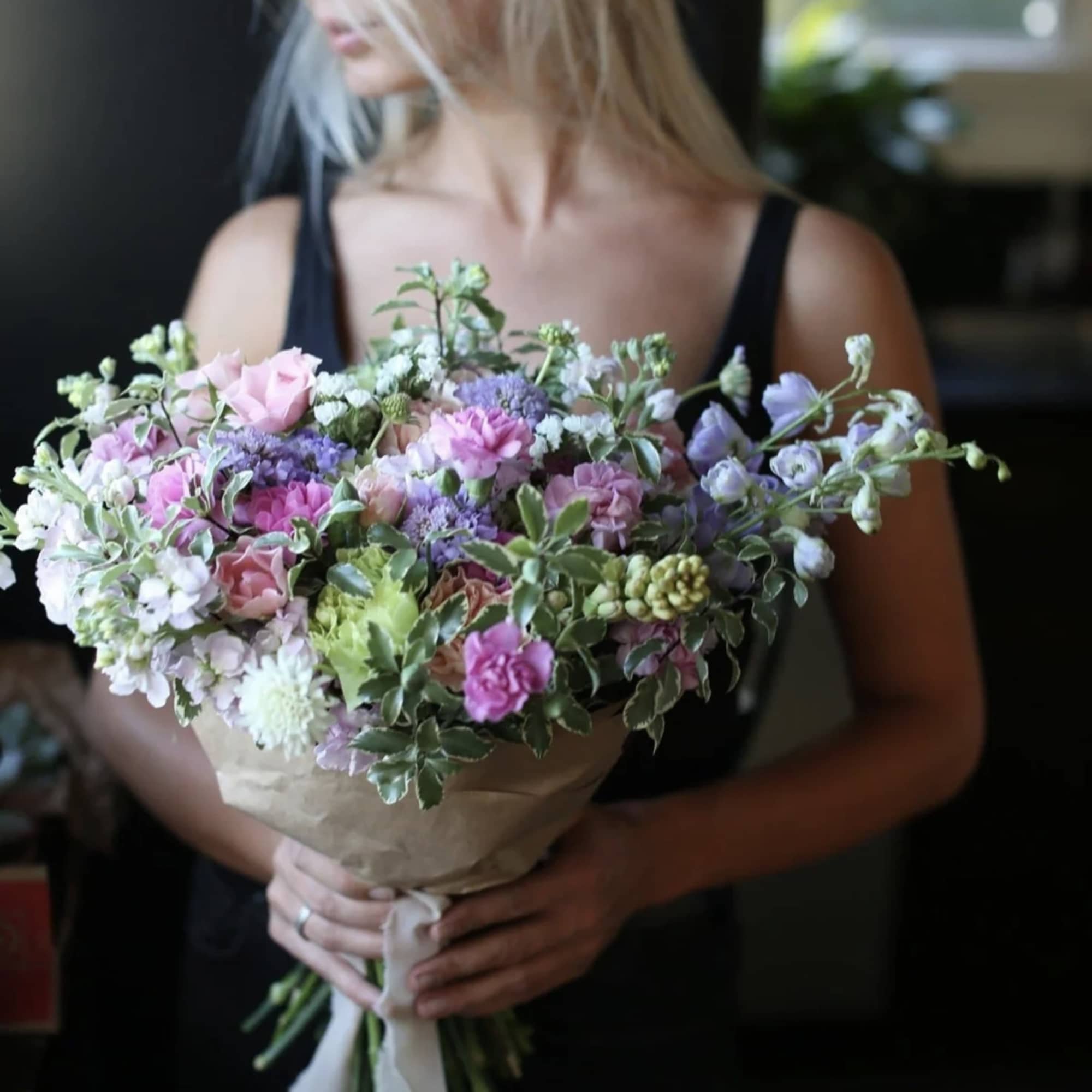 Woman holding a pastel mixed bouquet with pink and lavender flowers