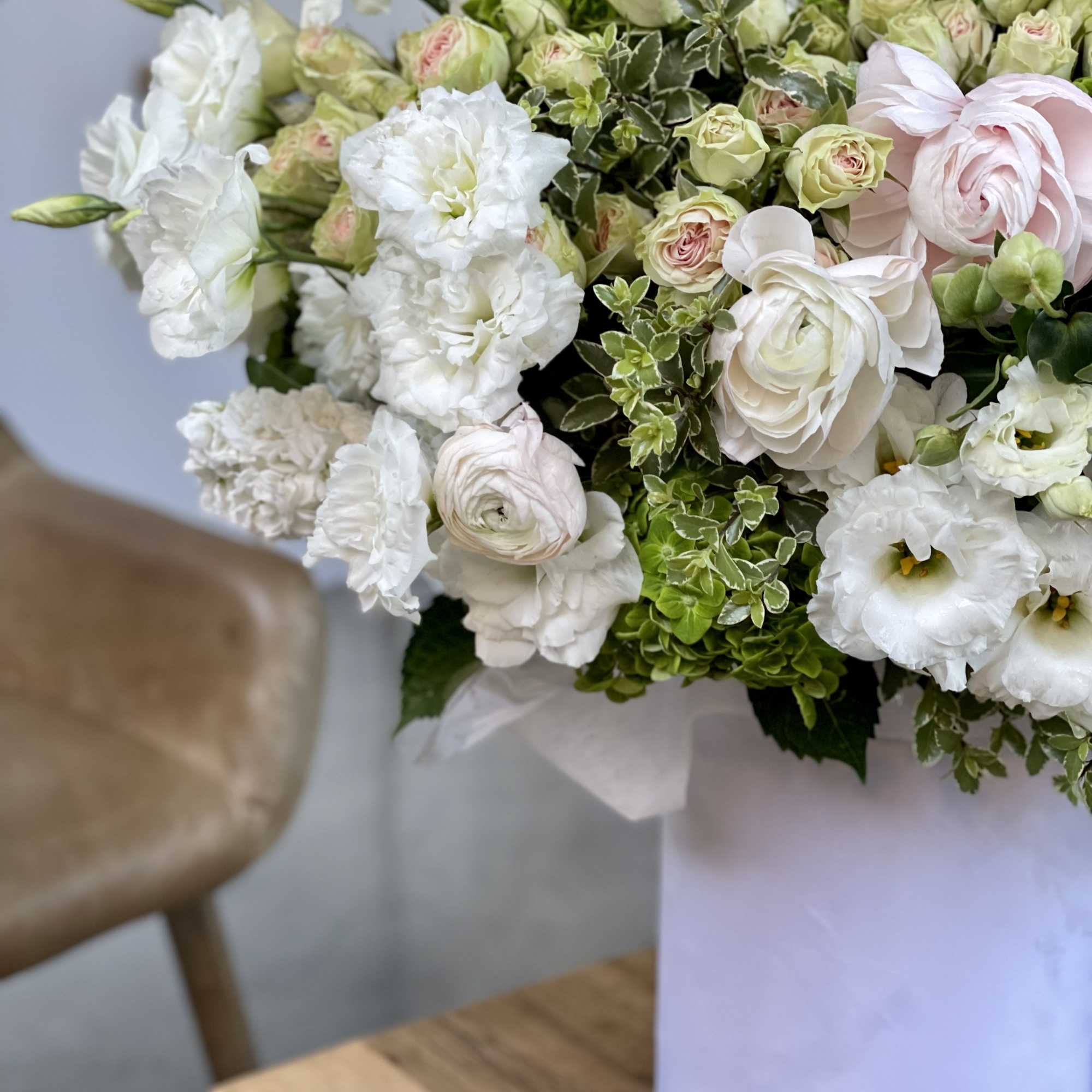 White and pale pink bouquet in a white vase