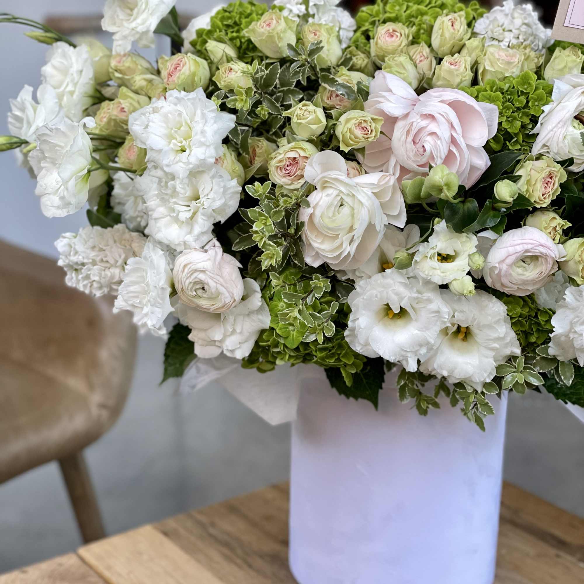 White and pale pink flowers arranged in a white vase, photo 6 of 12