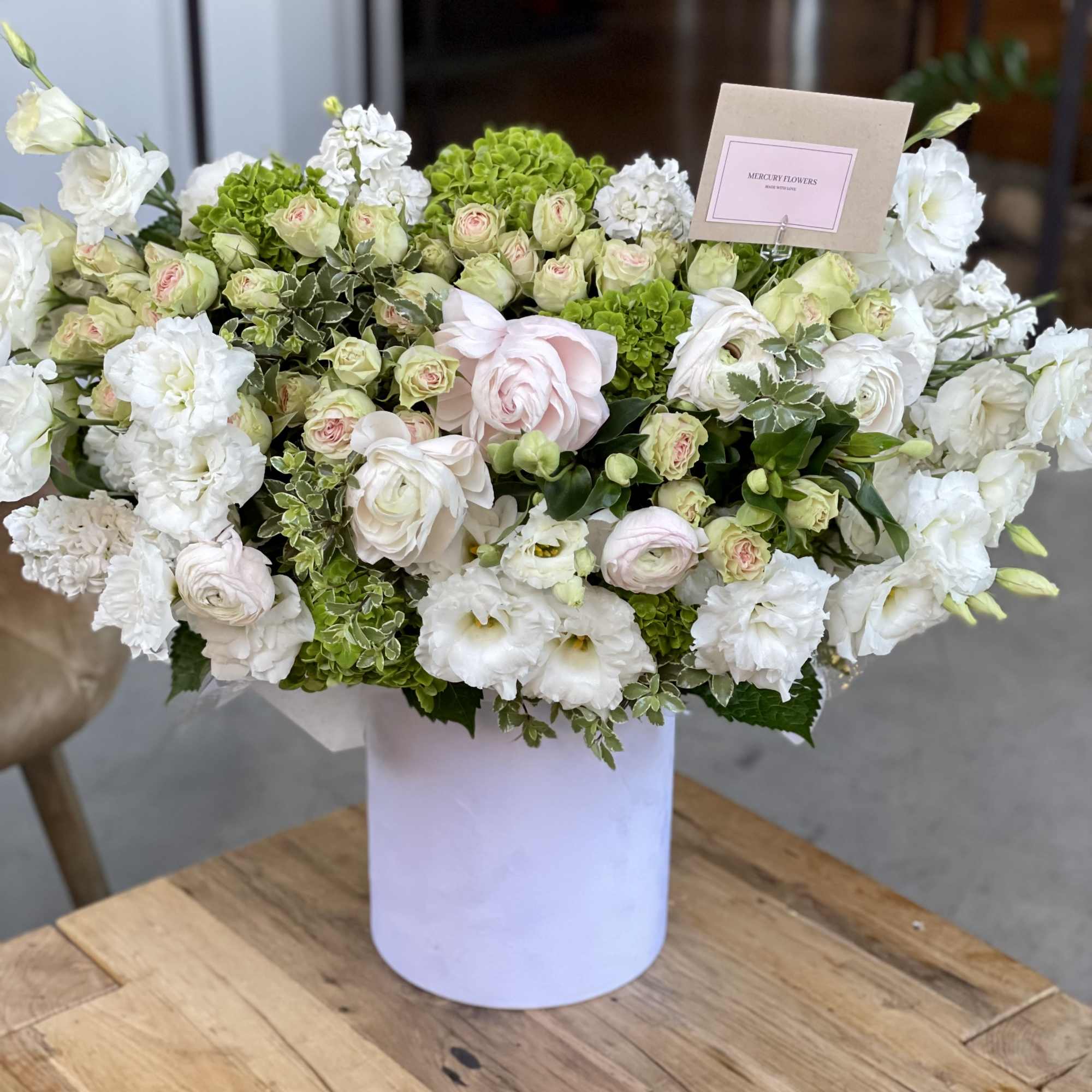White and pale pink floral arrangement in a white vase, photo 7 of 12
