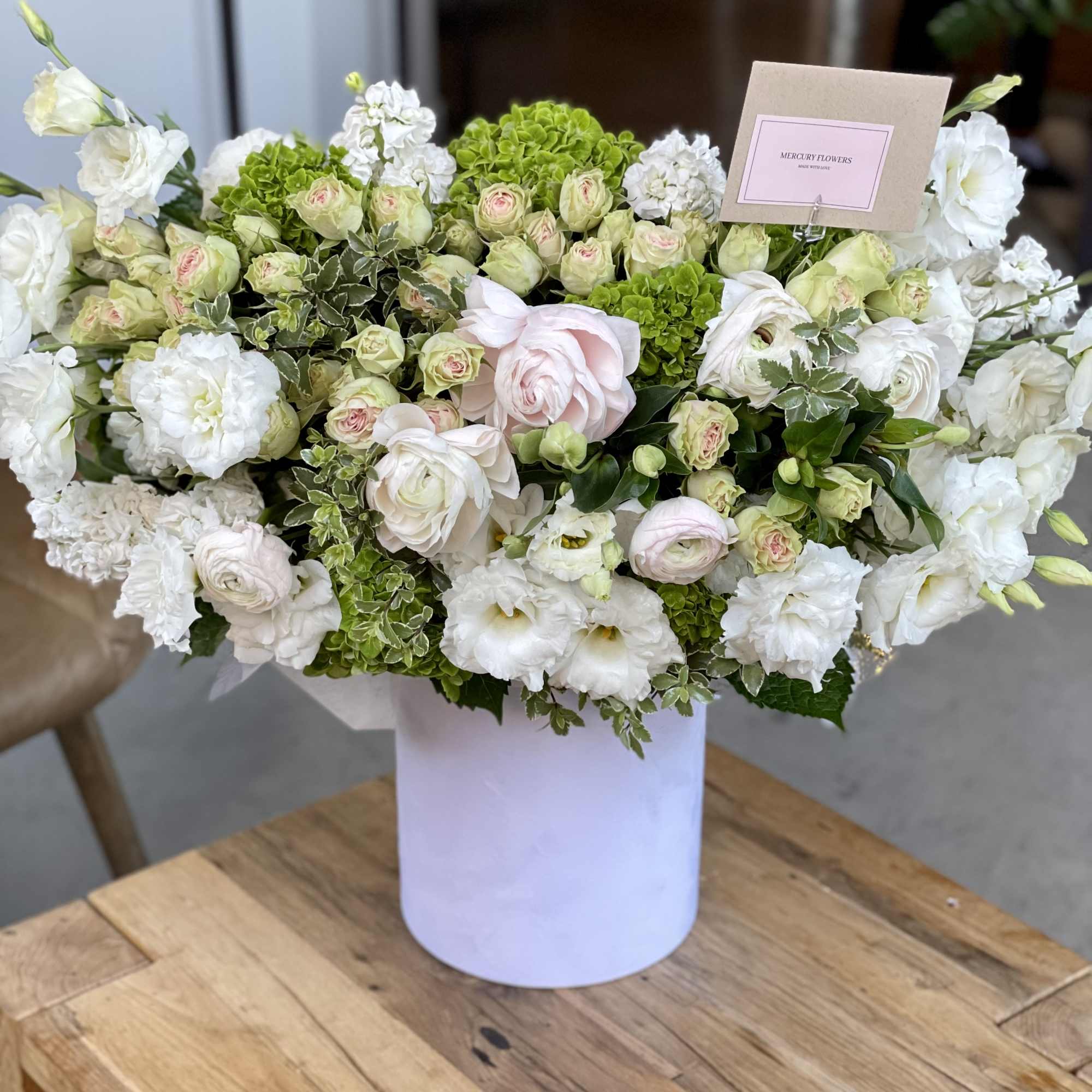 White and pale pink floral arrangement in a white vase, photo 8 of 12