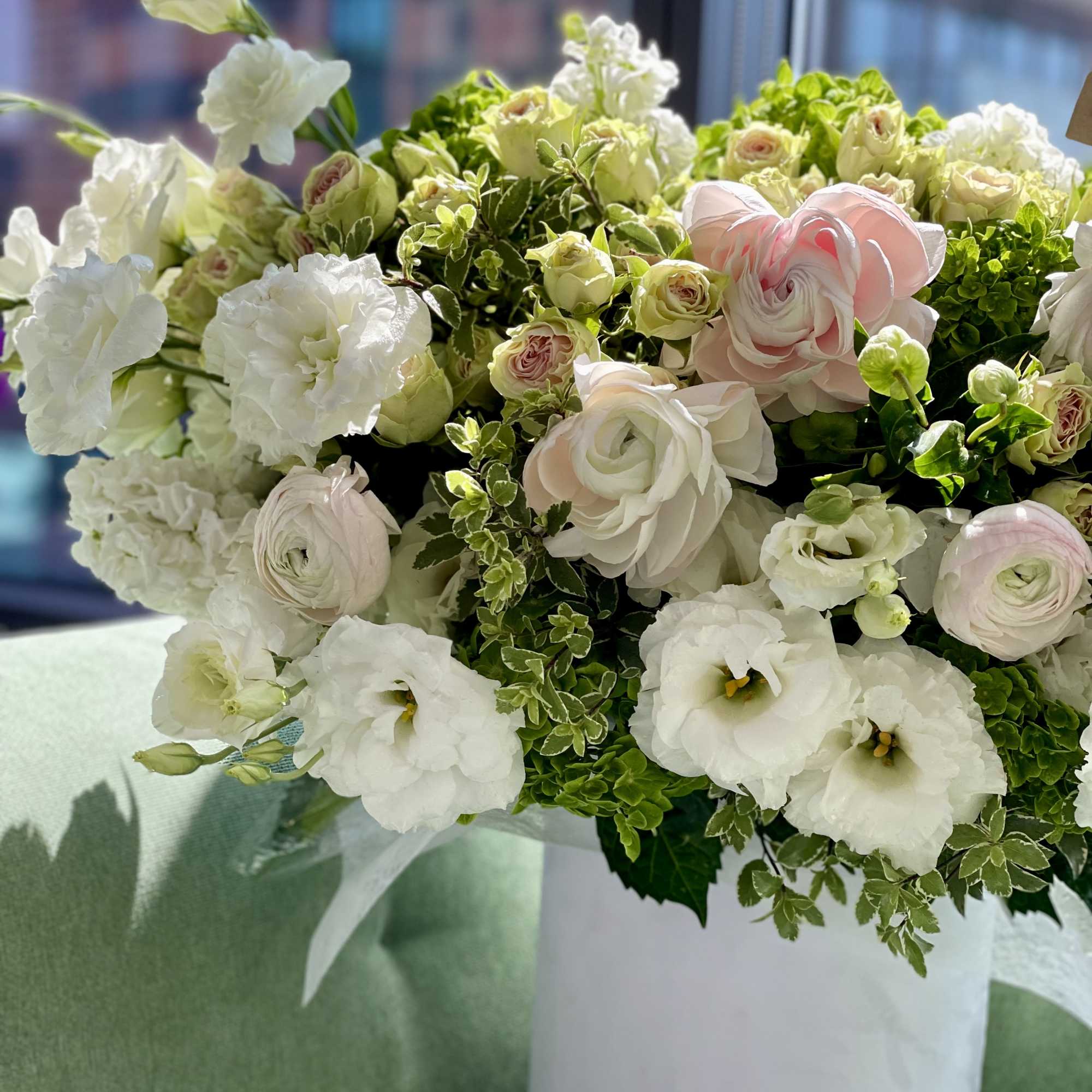 White and pale pink floral arrangement in a white vase, photo 5 of 12