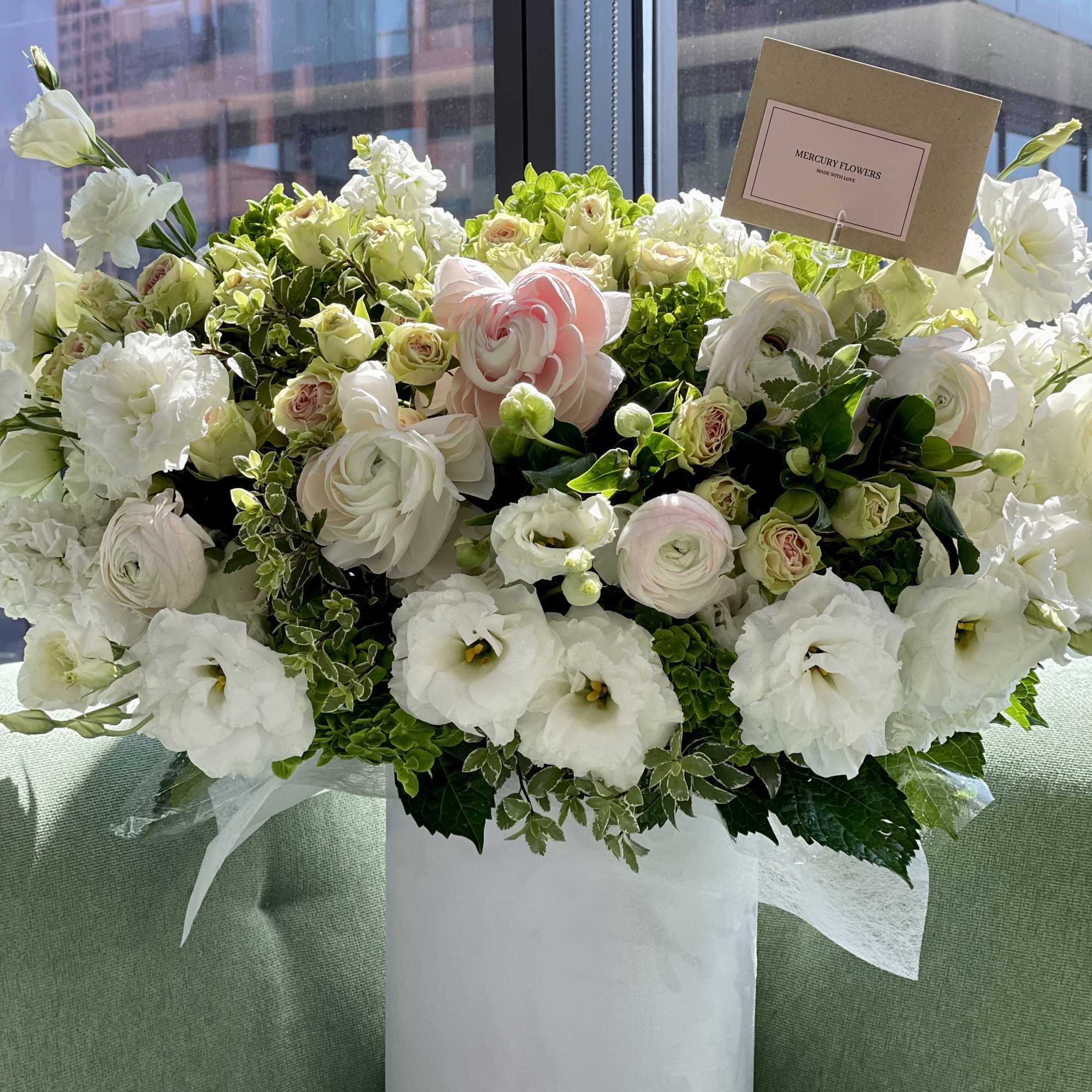 Large white and blush floral arrangement in a white vase