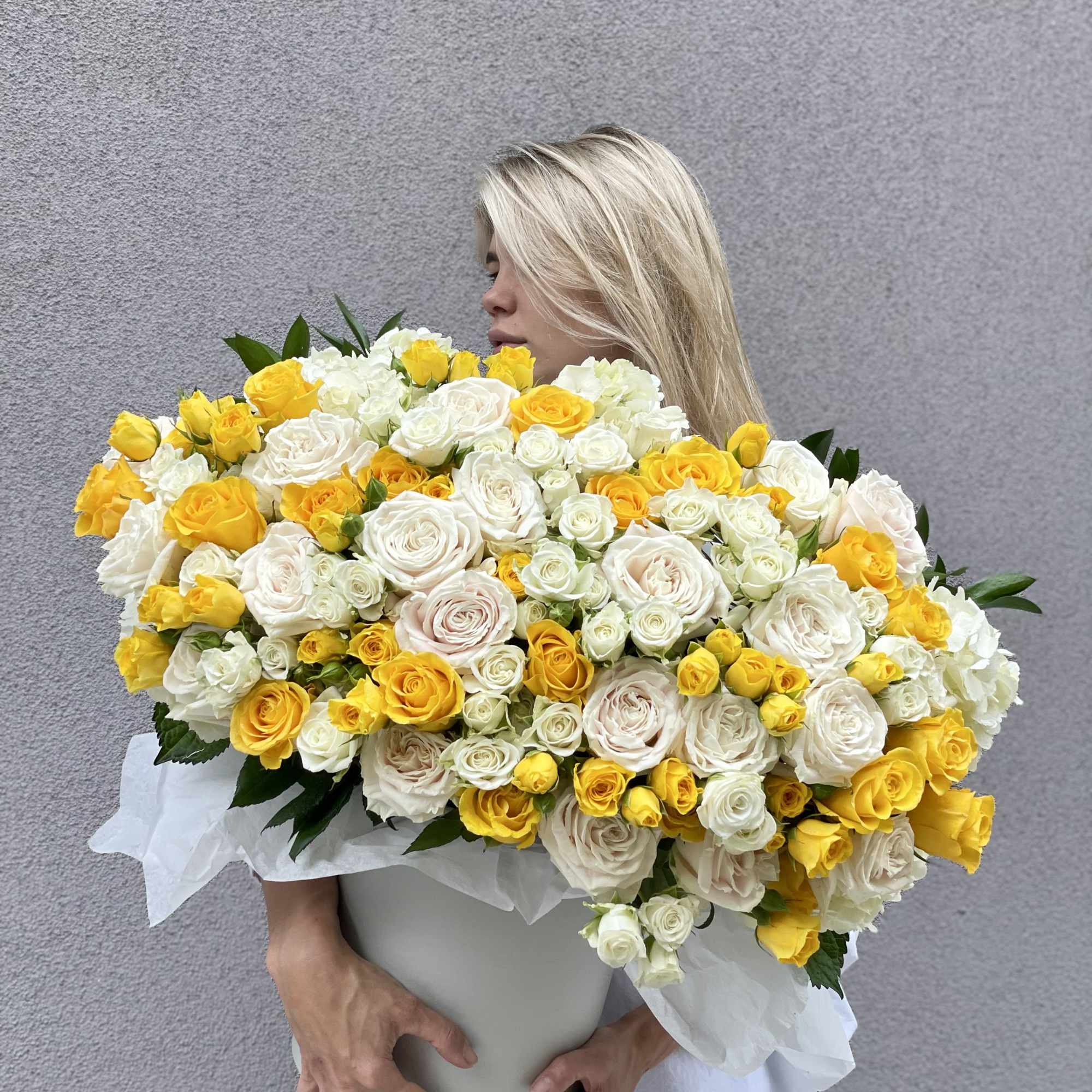 Large bouquet of white and yellow roses in a white container