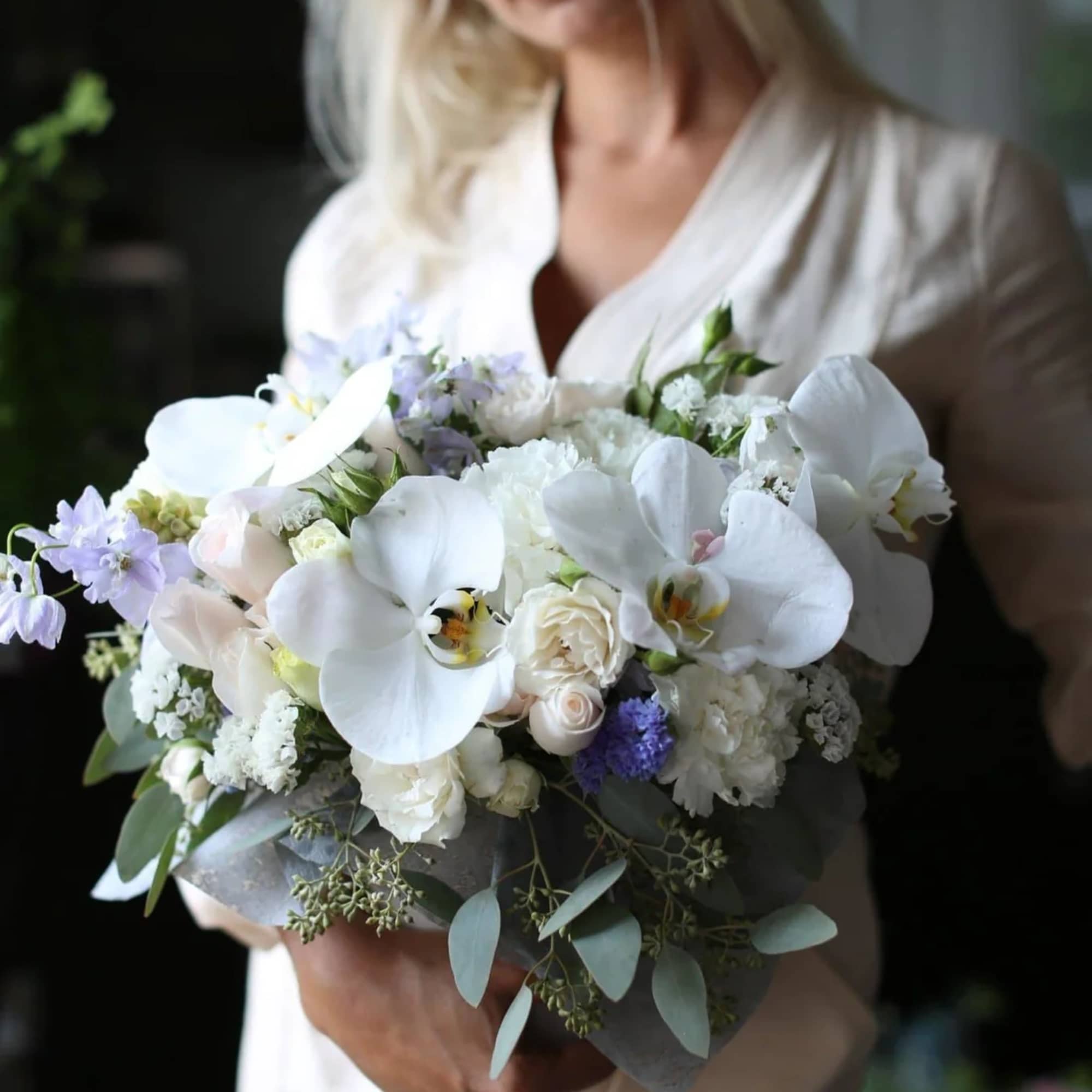 Woman holding a white and lavender bridal bouquet