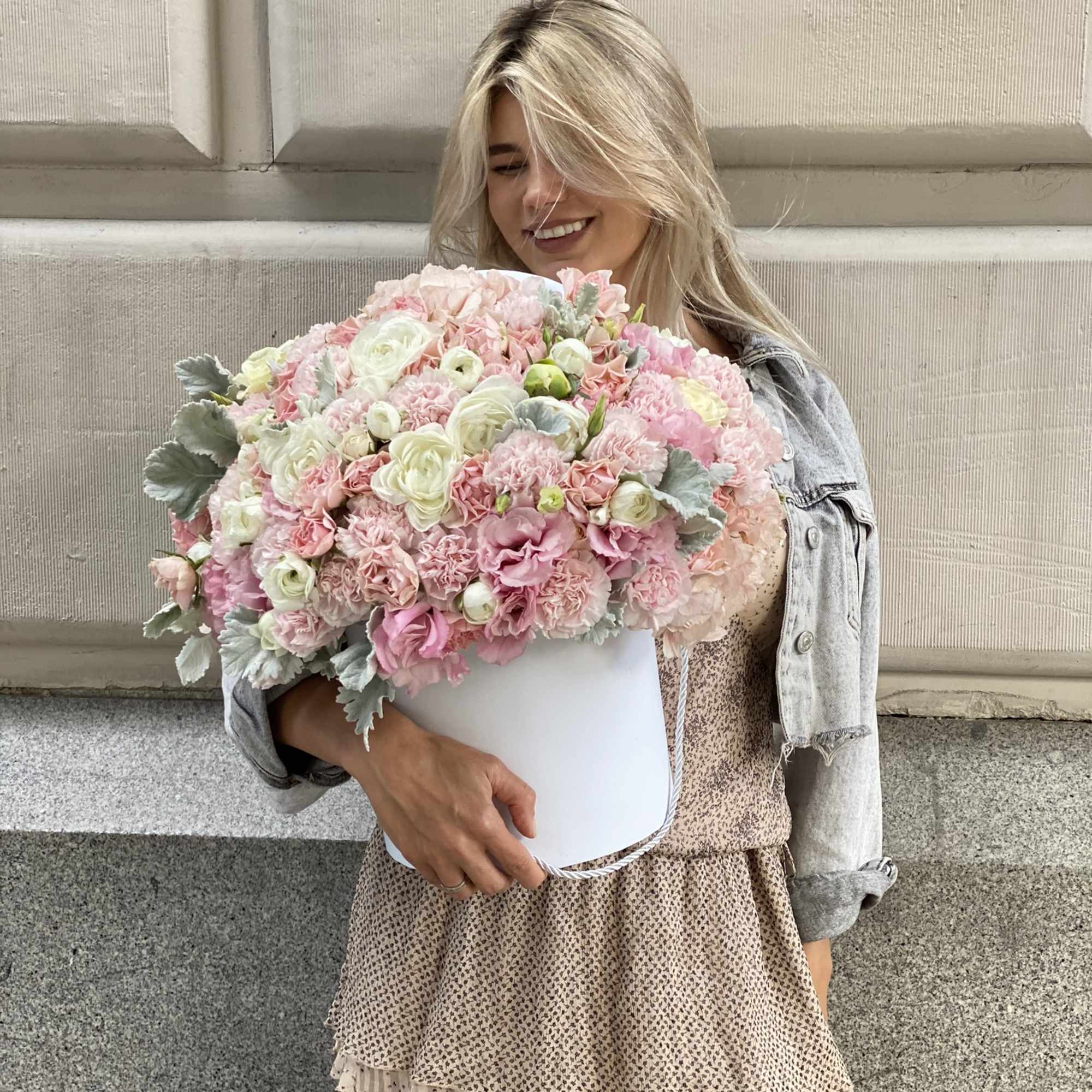 Woman holding a large pink and white flower box arrangement