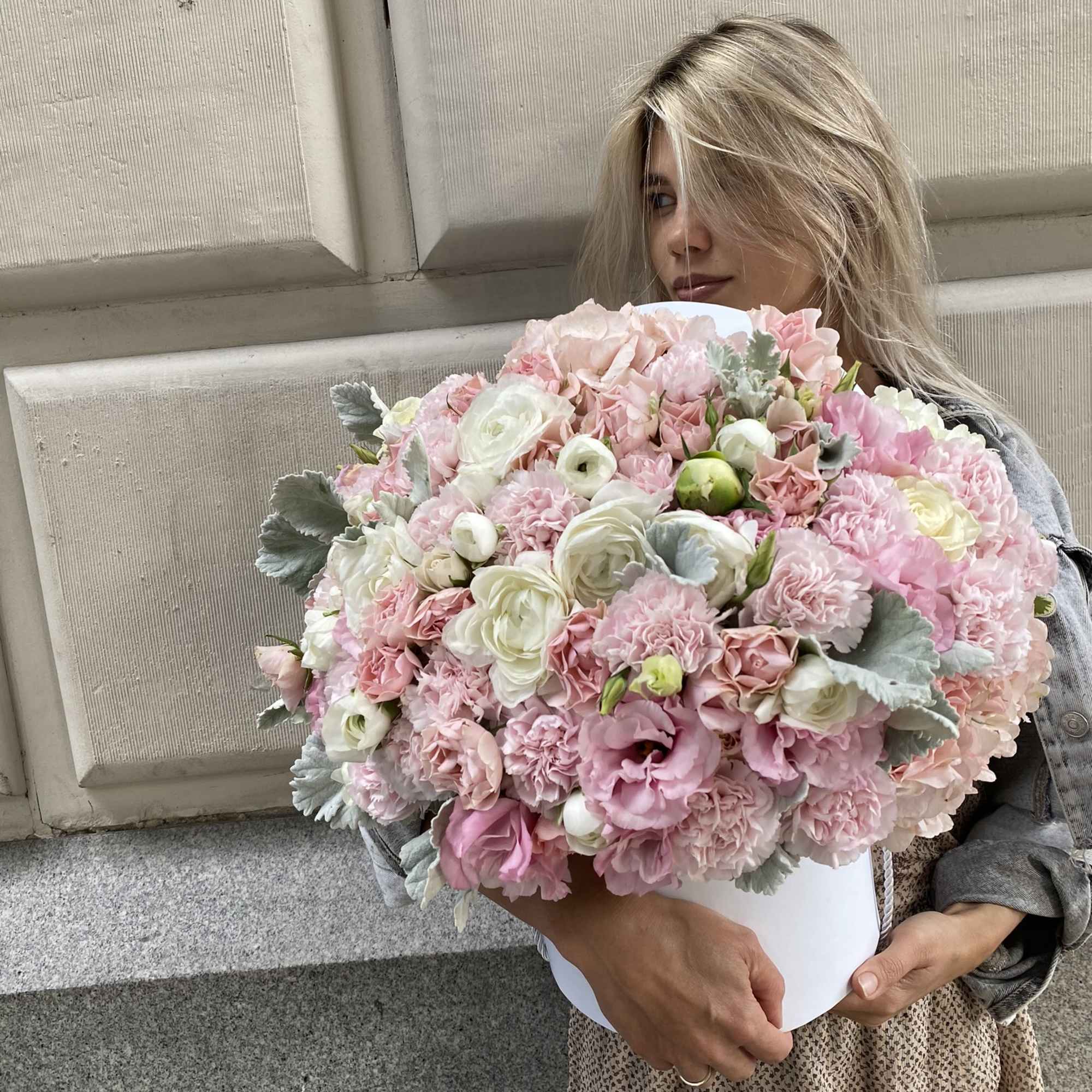 Large pink and white bouquet held by a woman