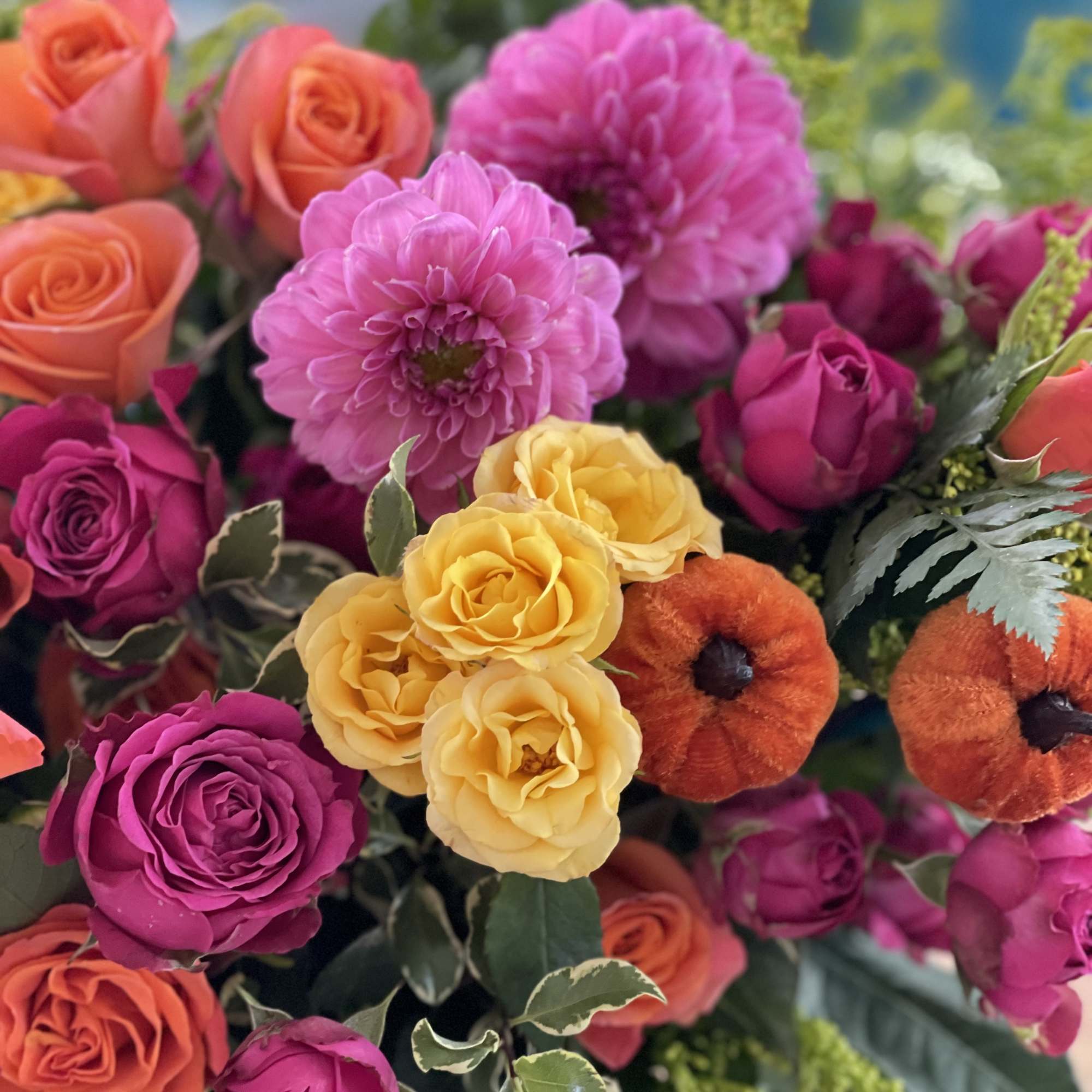 Colorful bouquet of roses and dahlias with orange accents