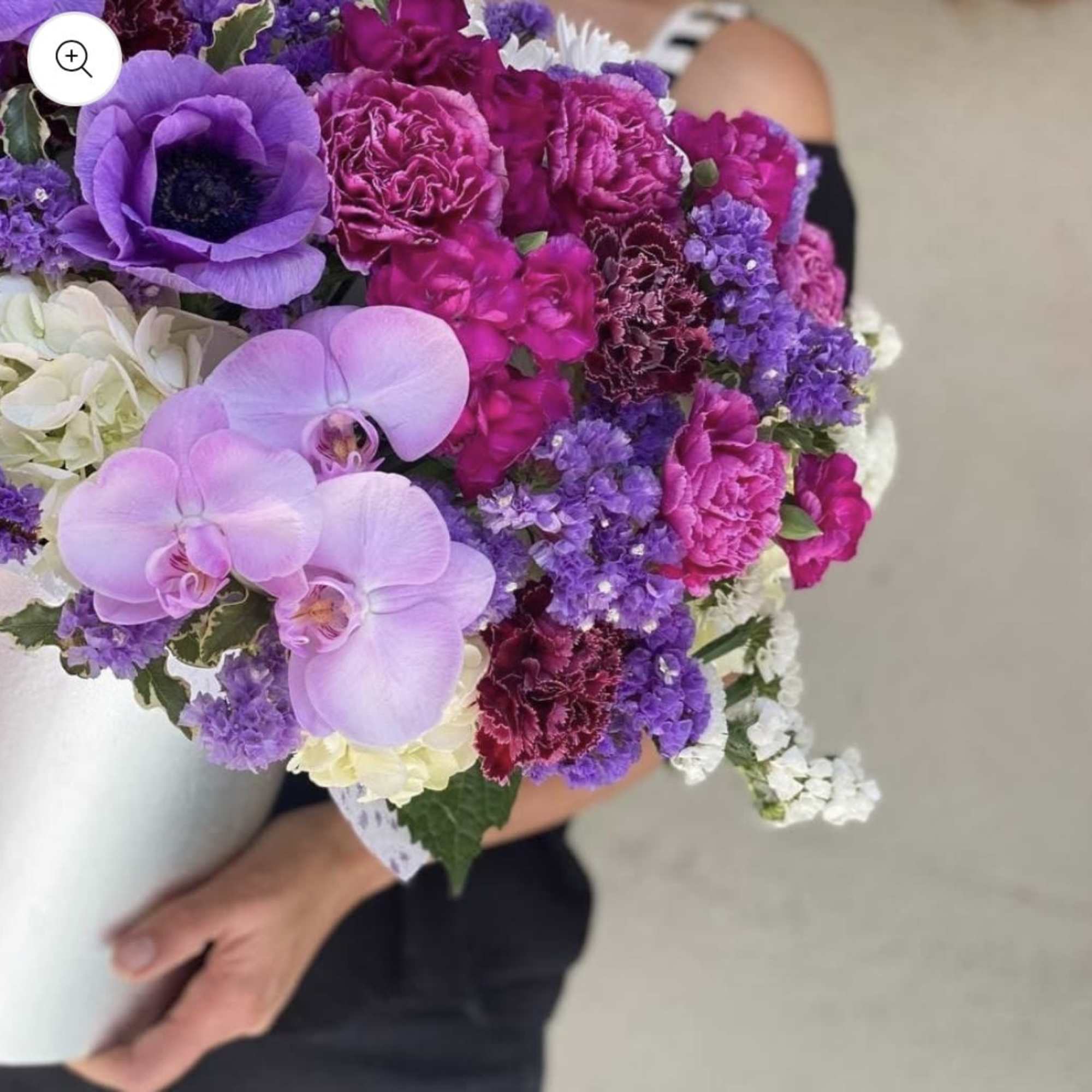 Purple and pink bouquet with orchids, carnations, and white filler flowers