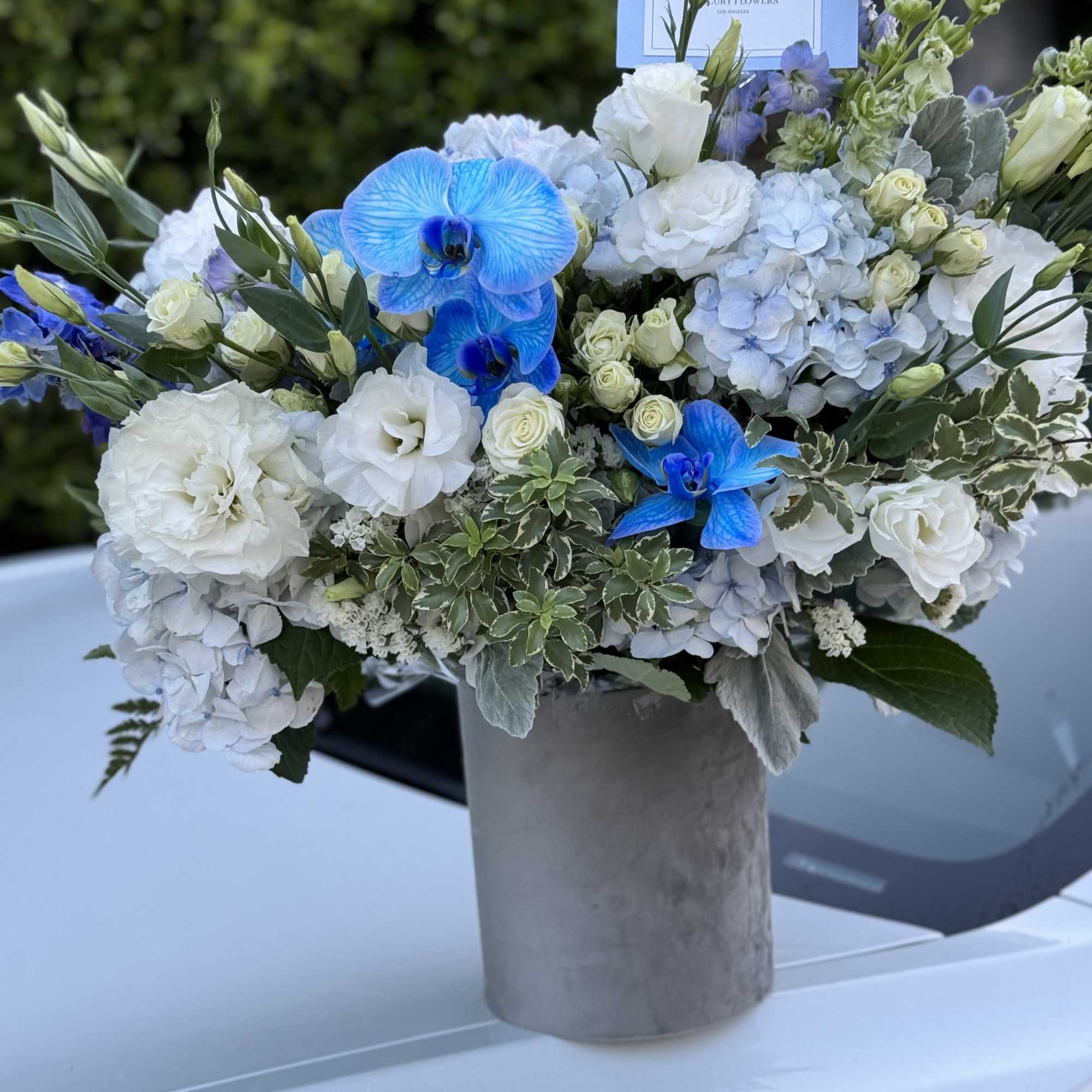 Blue and white floral arrangement in a gray vase