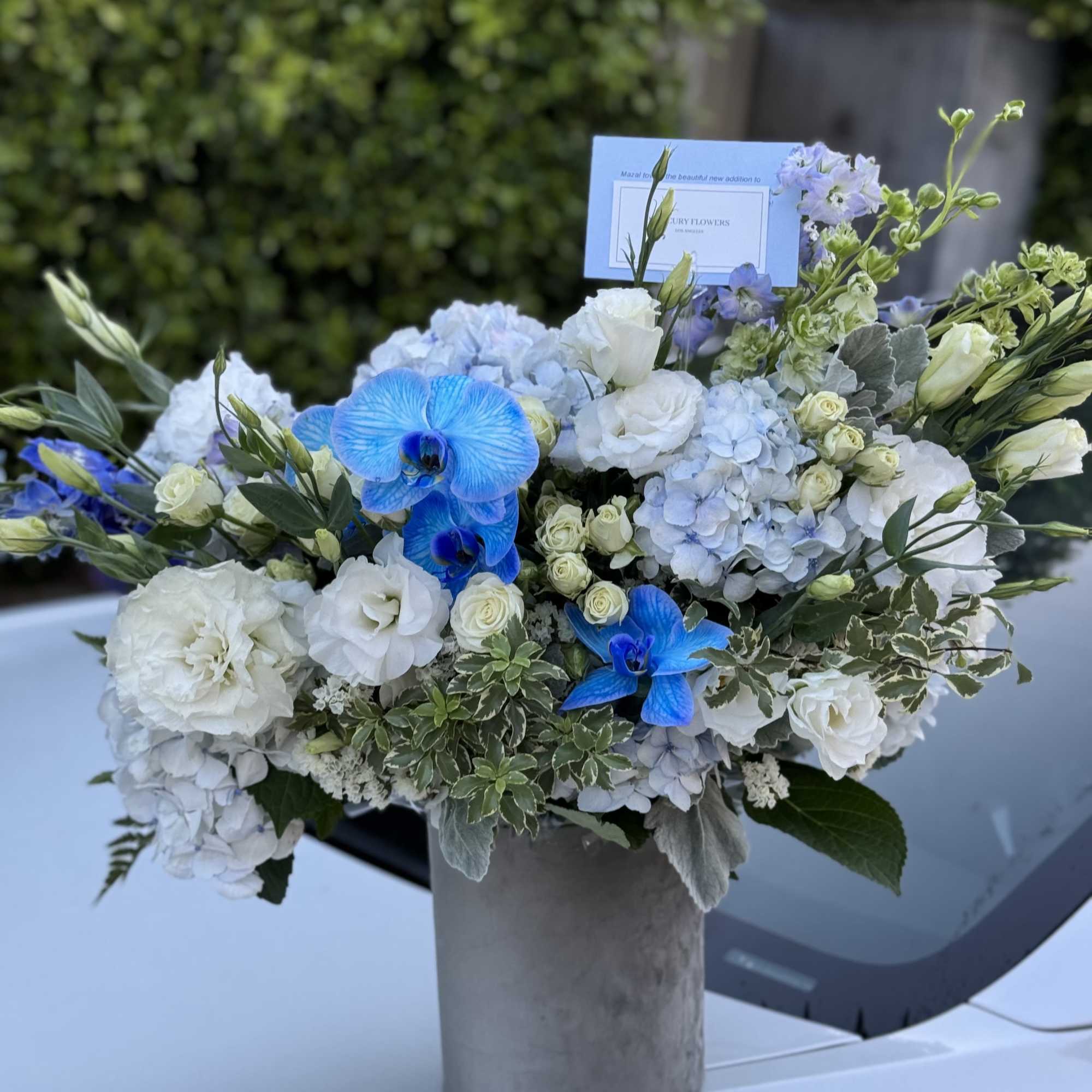 Blue and white floral arrangement in a gray vase, photo 6 of 7