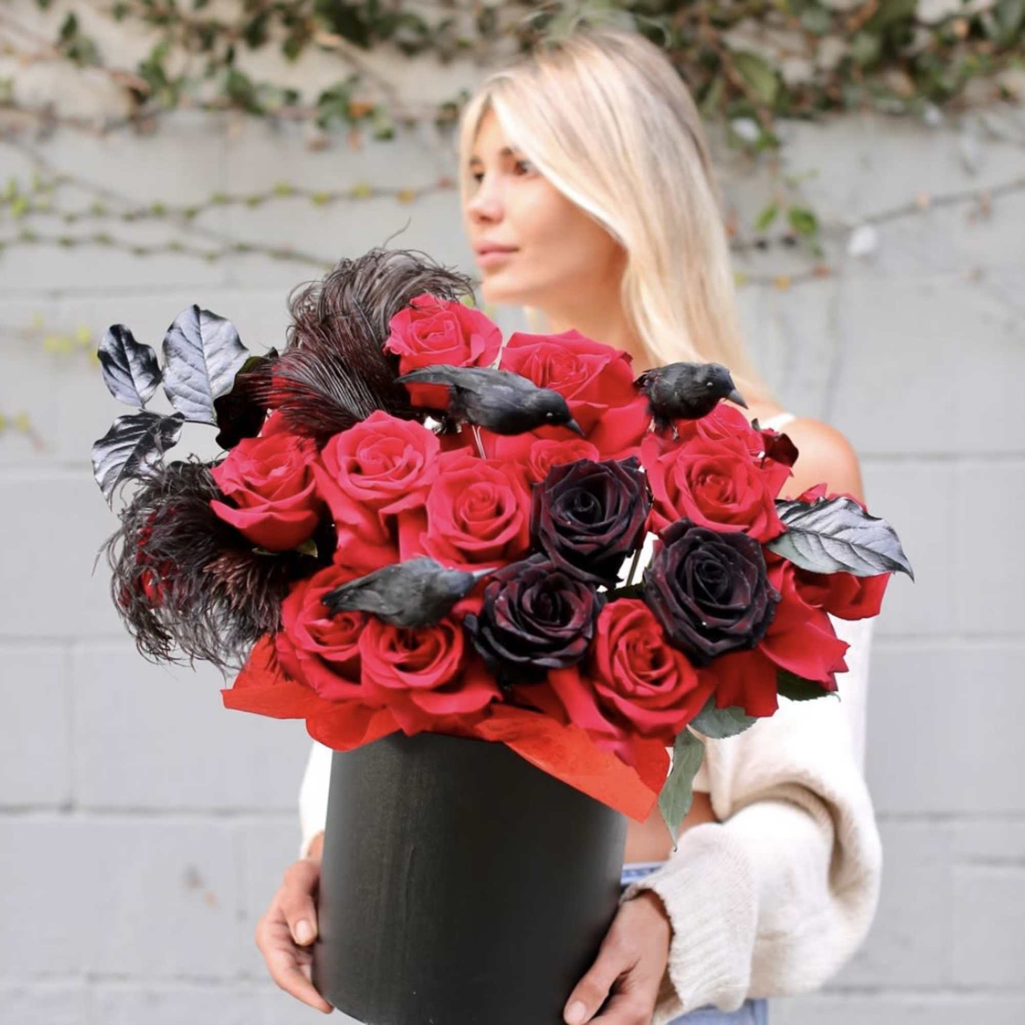 Woman holding a black box of red and black roses