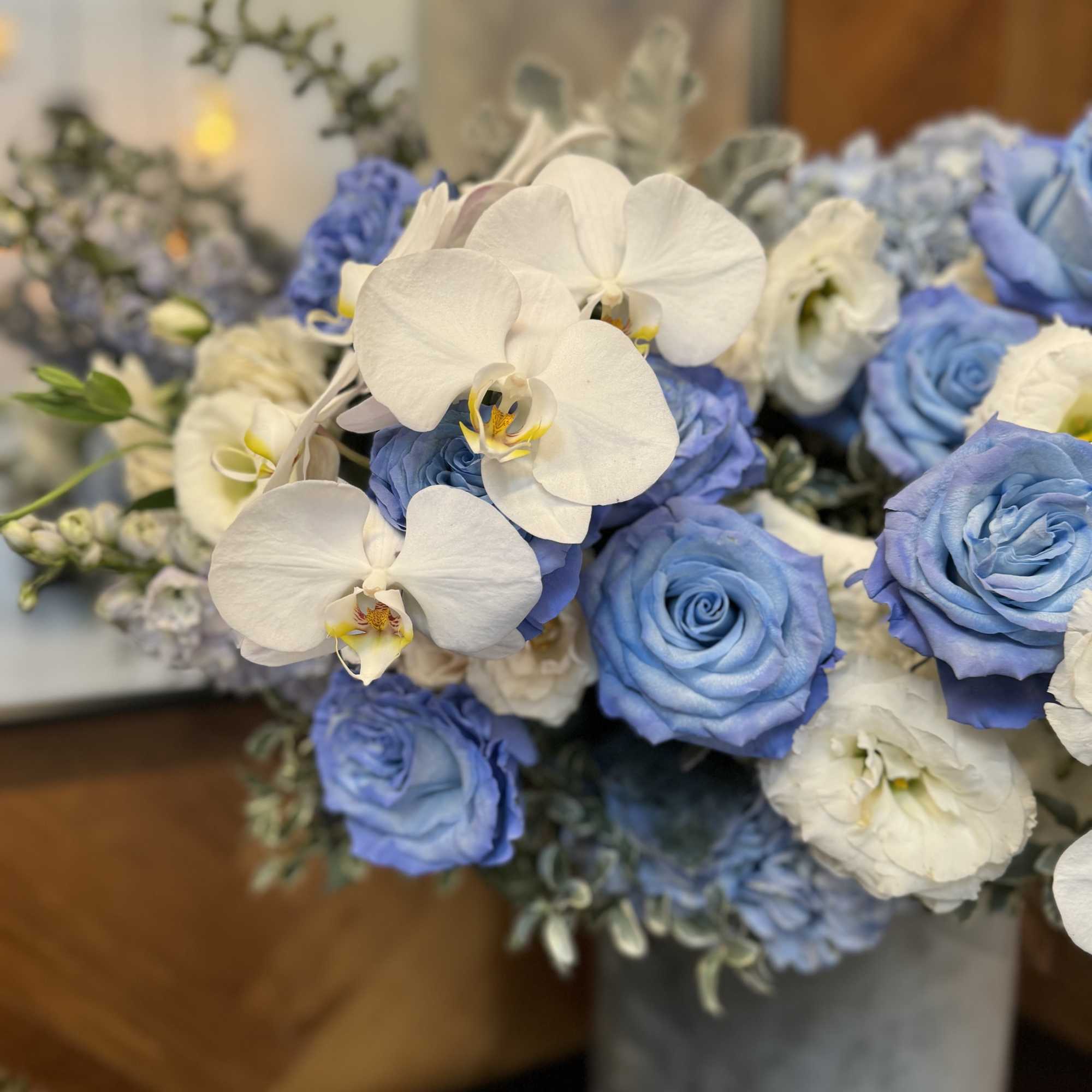 Blue roses and white orchids in a vase
