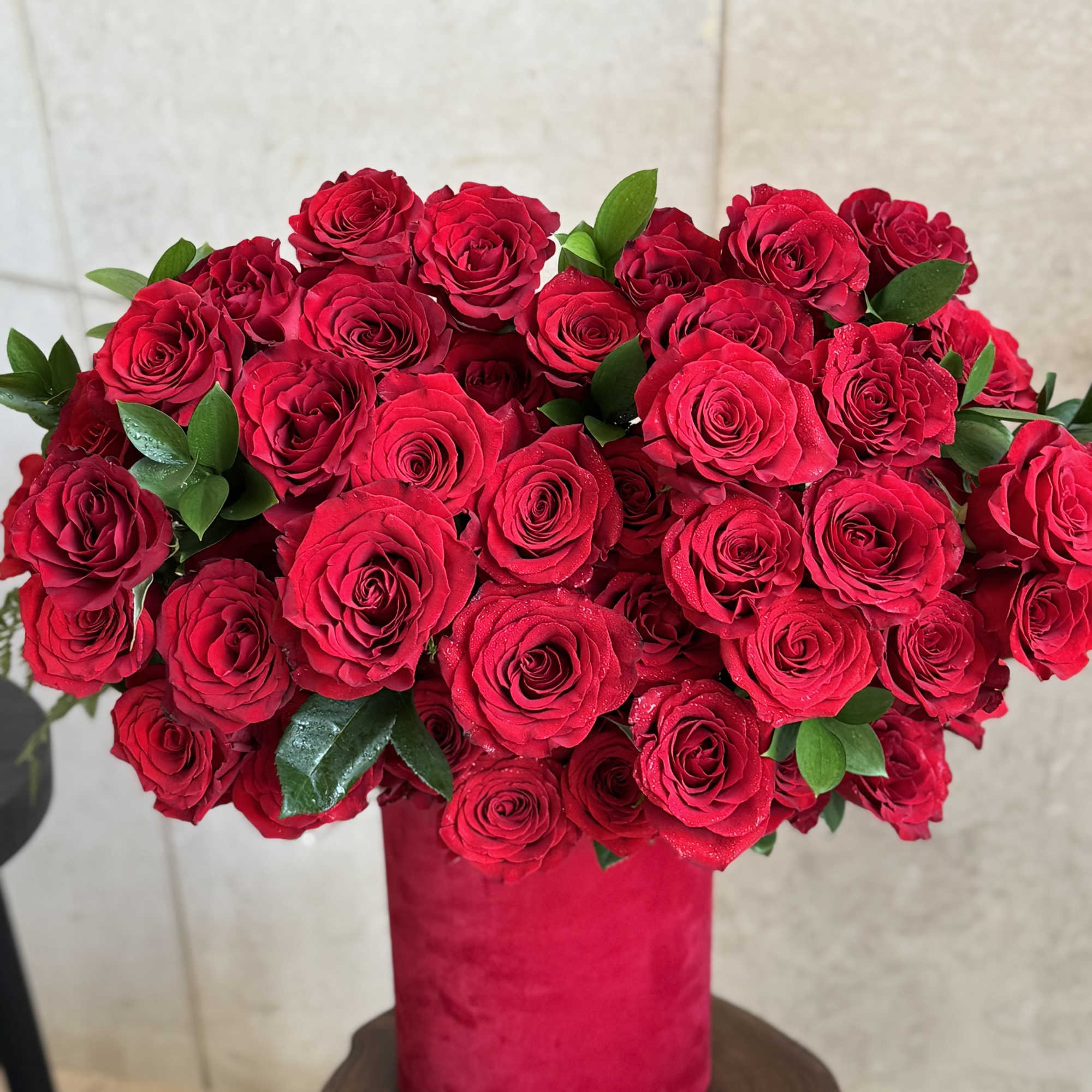 Red rose bouquet in a pink cylindrical vase