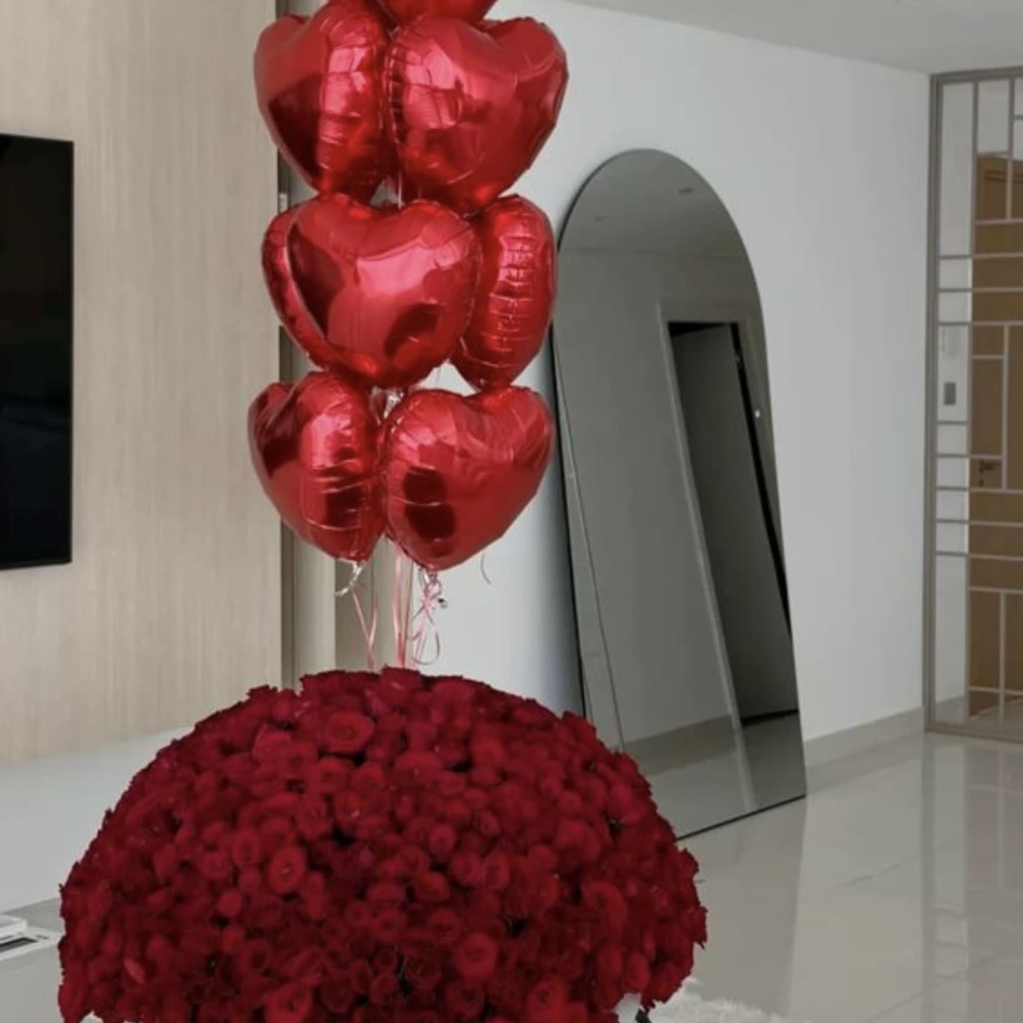 Large red rose arrangement with heart-shaped balloons