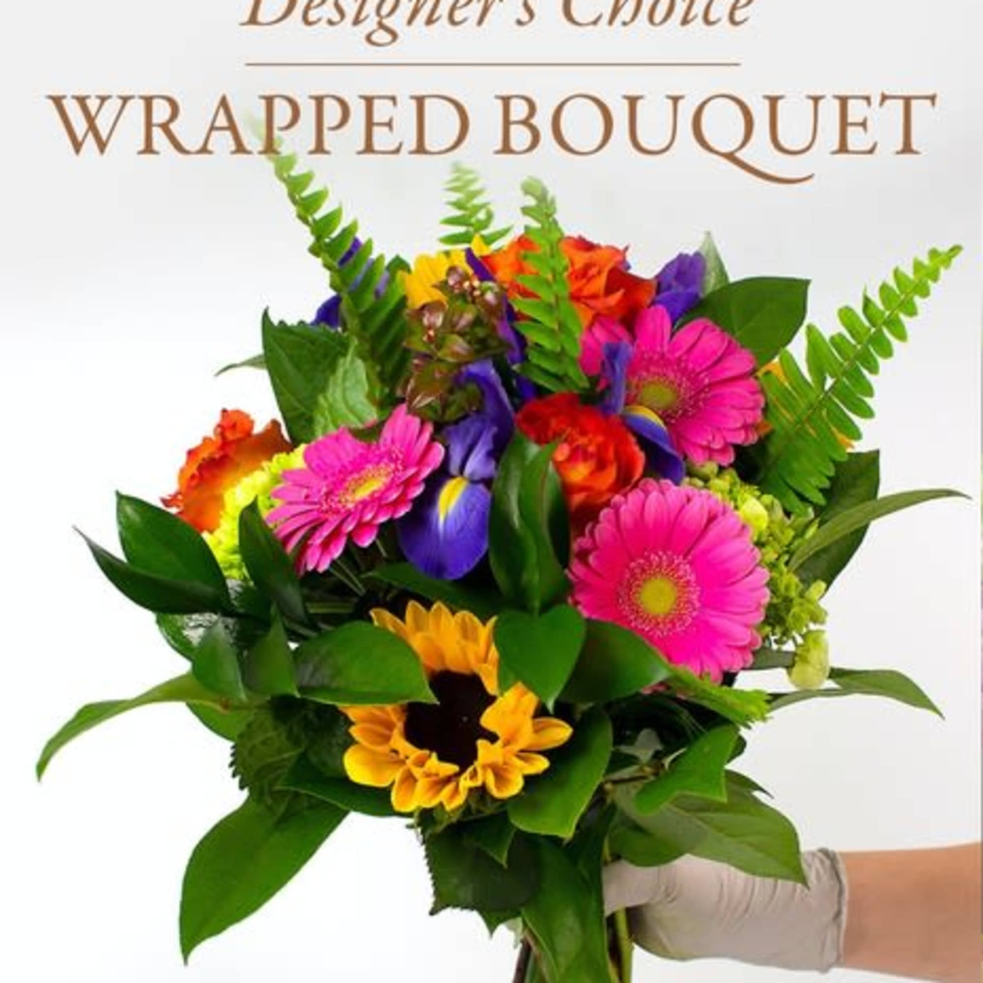 Wrapped bouquet of mixed bright flowers held in a gloved hand