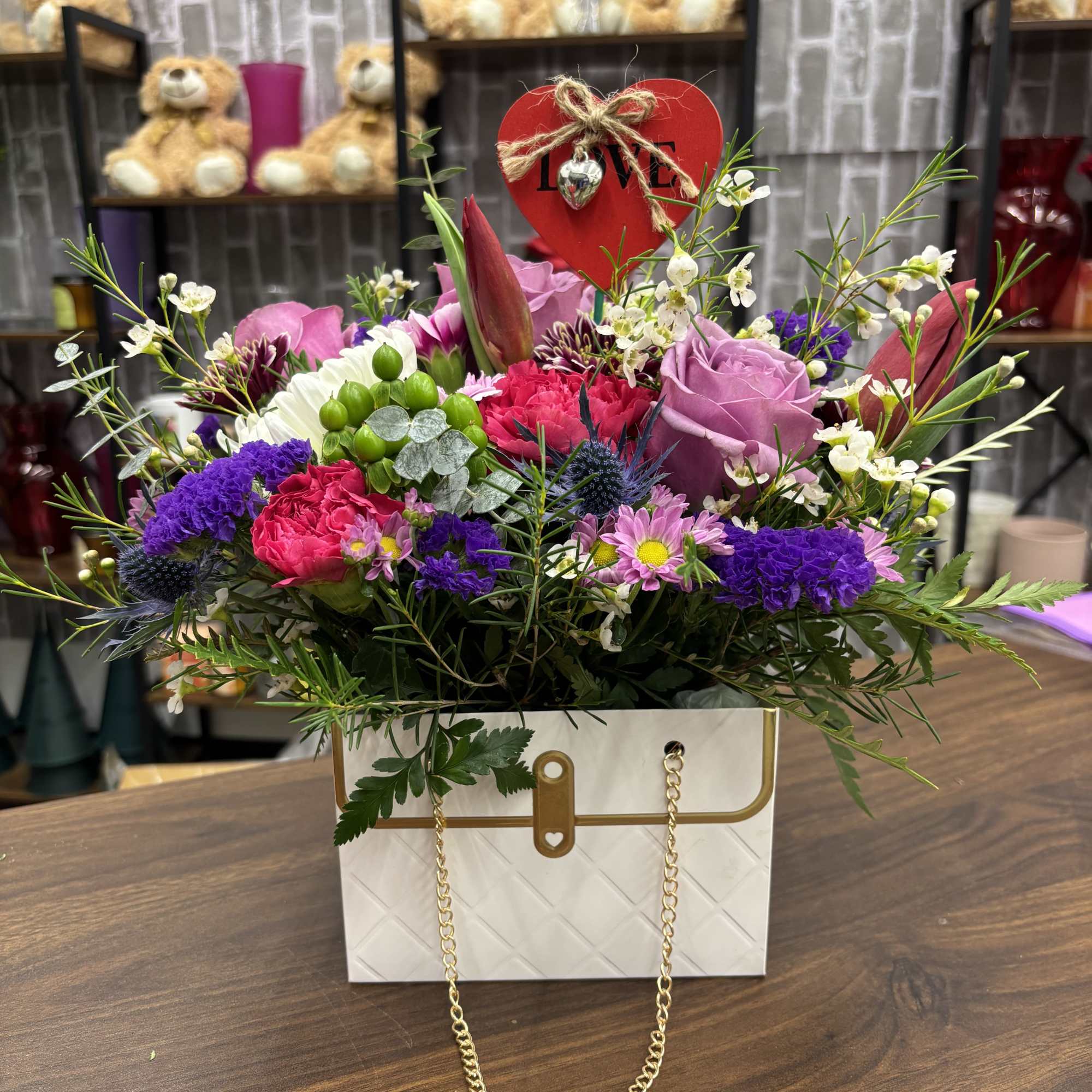 Mixed bouquet in a white gift bag with a red heart topper
