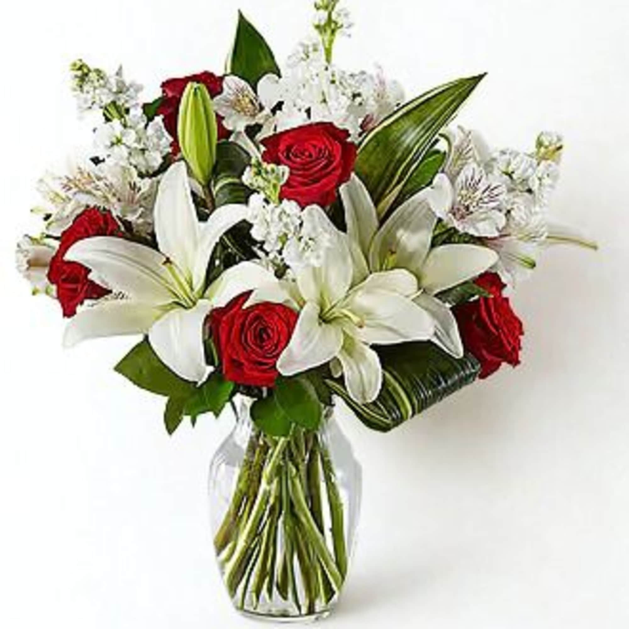 Bouquet of red roses and white lilies in a clear glass vase