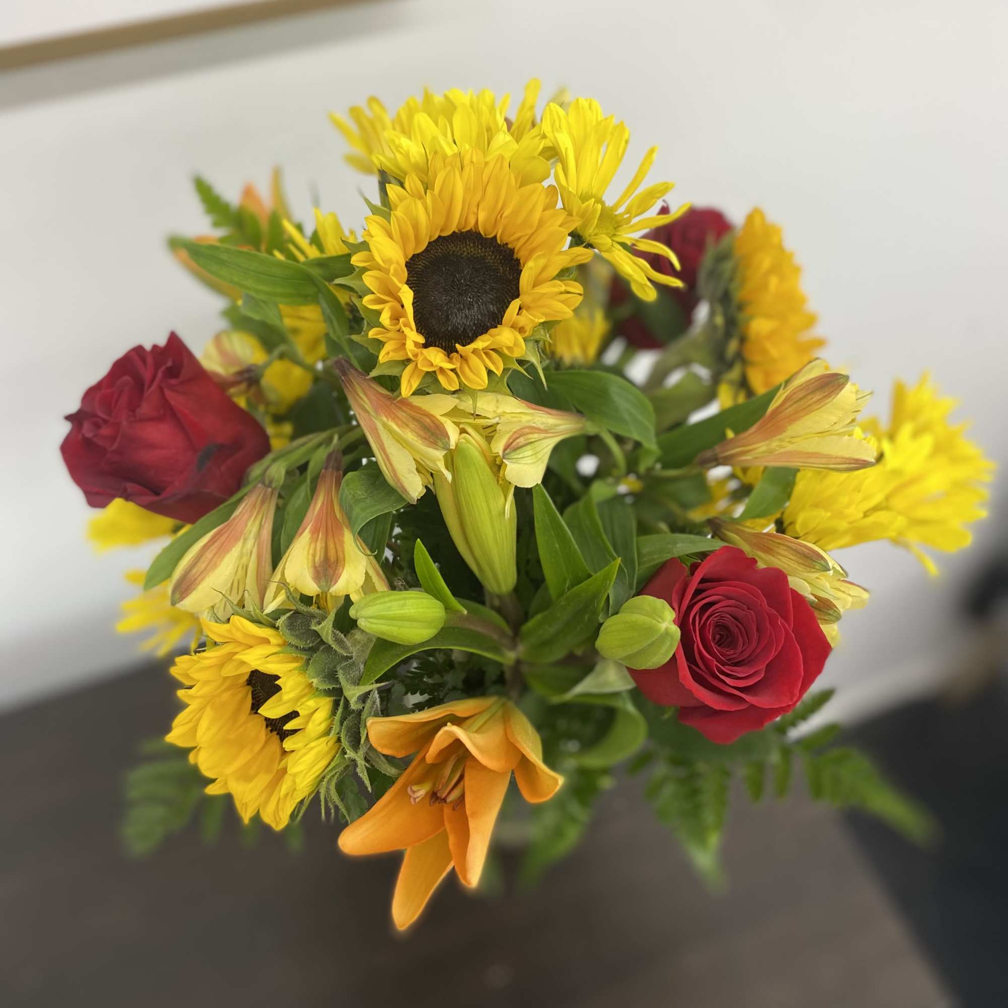 Bouquet with yellow sunflowers, red roses, and orange lilies