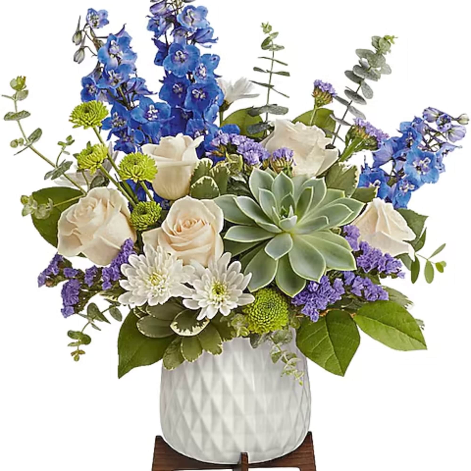 Blue and white floral arrangement in a white vase with a succulent centerpiece