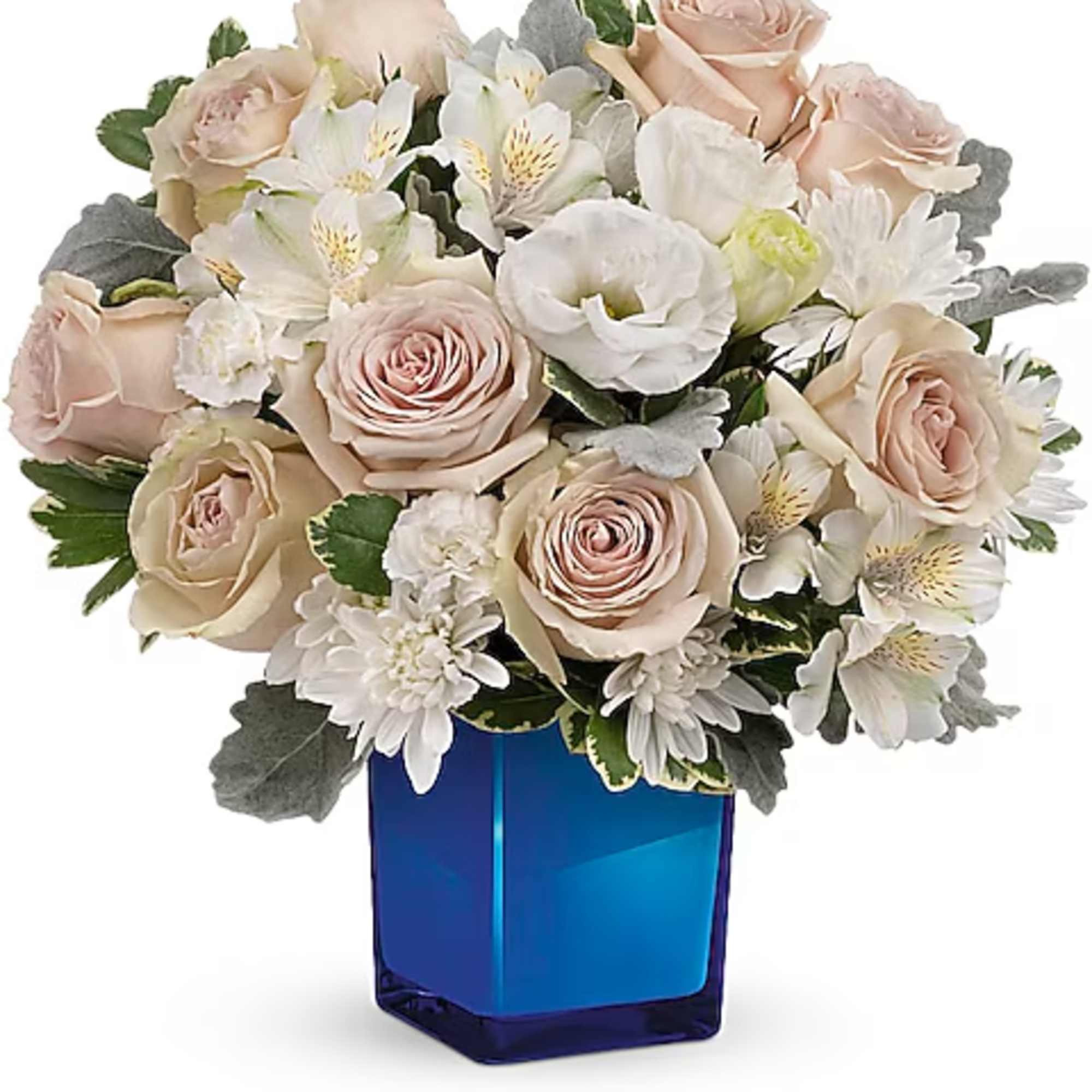 Blush roses and white flowers arranged in a blue glass vase